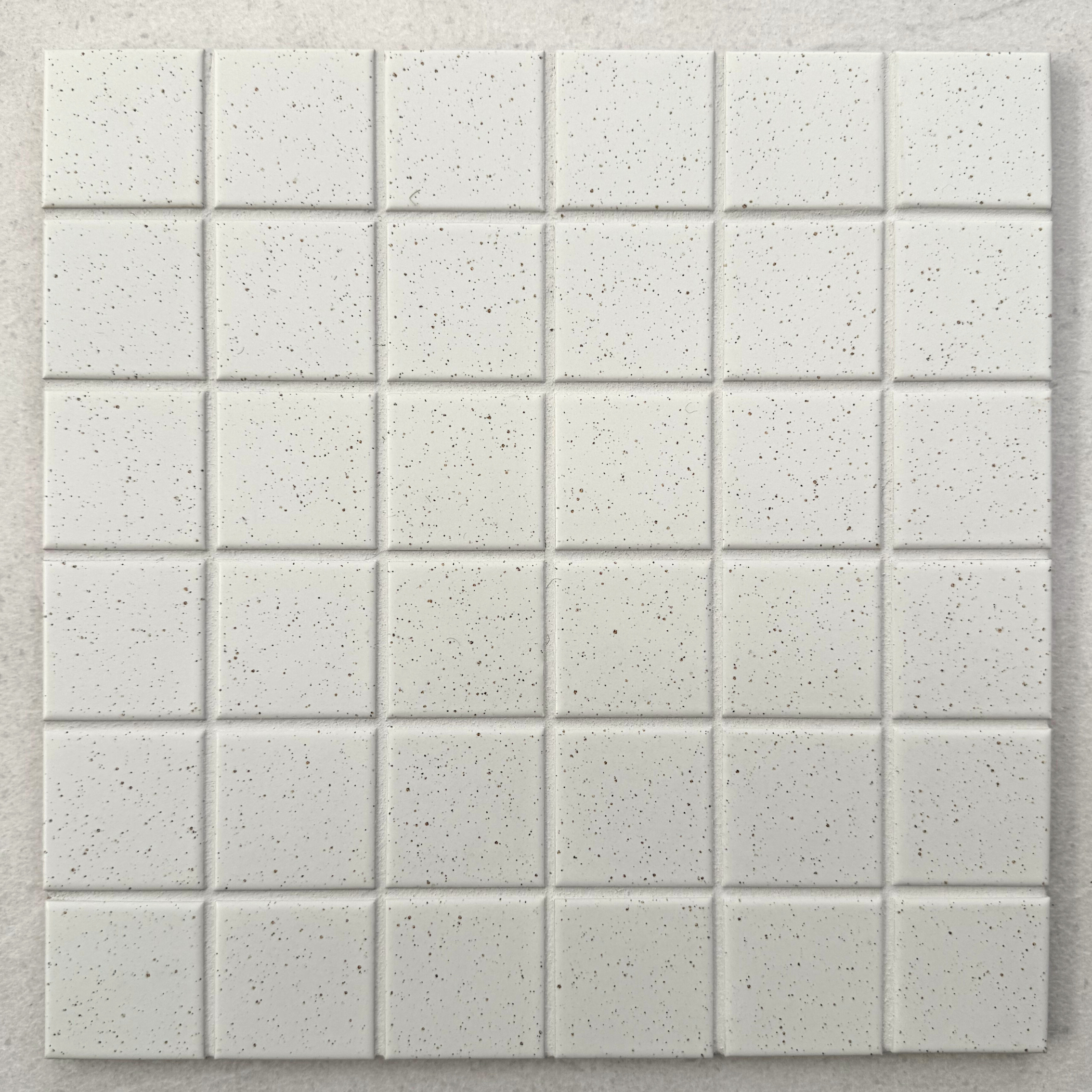 Rasa Block Off White porcelain mosaic tile sheet featuring a six-by-six grid of square tiles with softly rounded edges and delicate dark speckling.