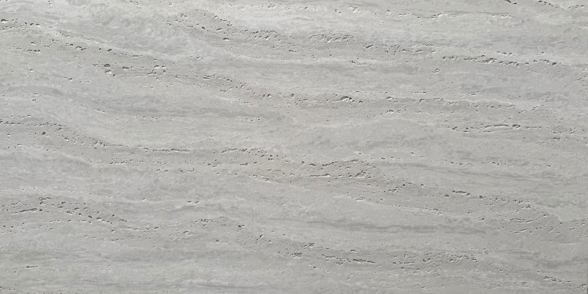Close-up of Travertine Classico Stone grey travertine-look porcelain tile showing soft horizontal striations, pale tonal variation and distinctive pitted detailing.