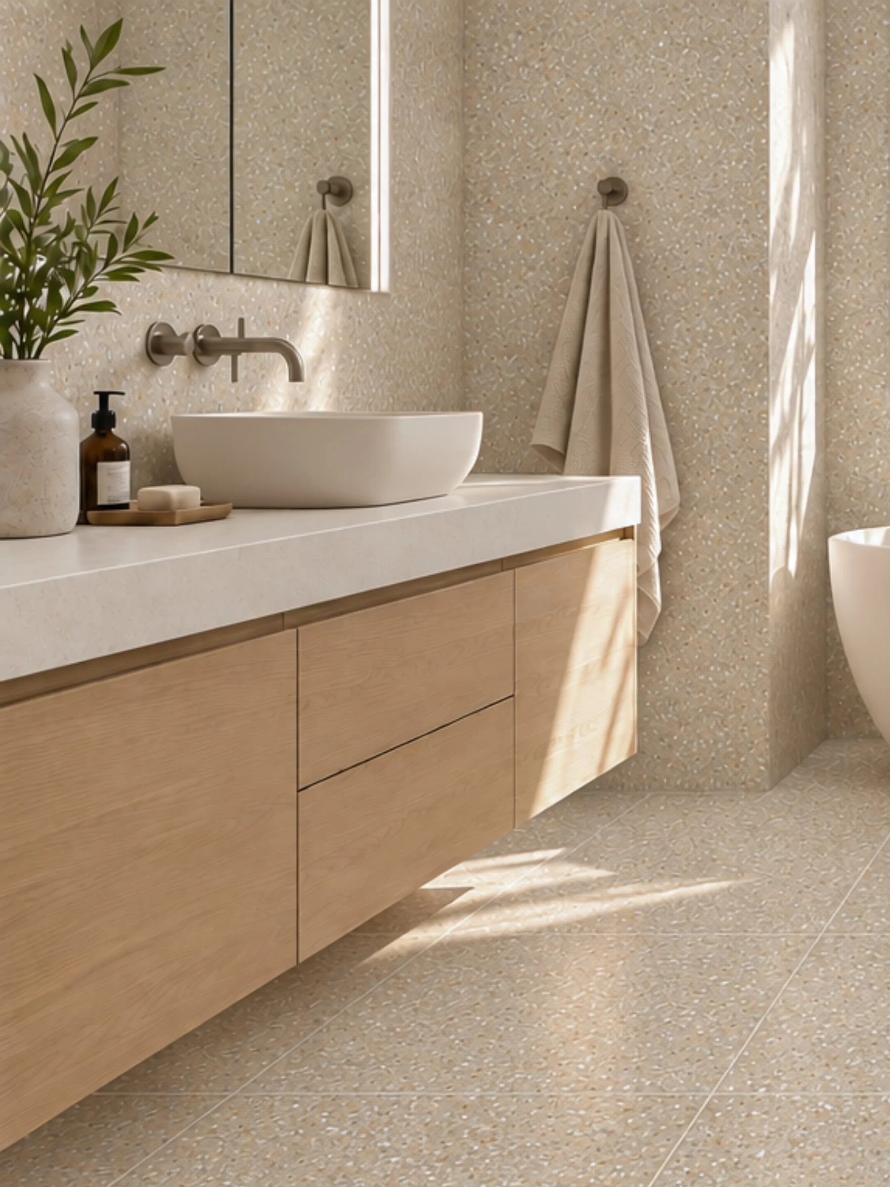 Contemporary bathroom featuring Terrazzo Earth beige speckled porcelain wall and floor tiles, a floating timber vanity, white vessel basin and brushed brass tapware.