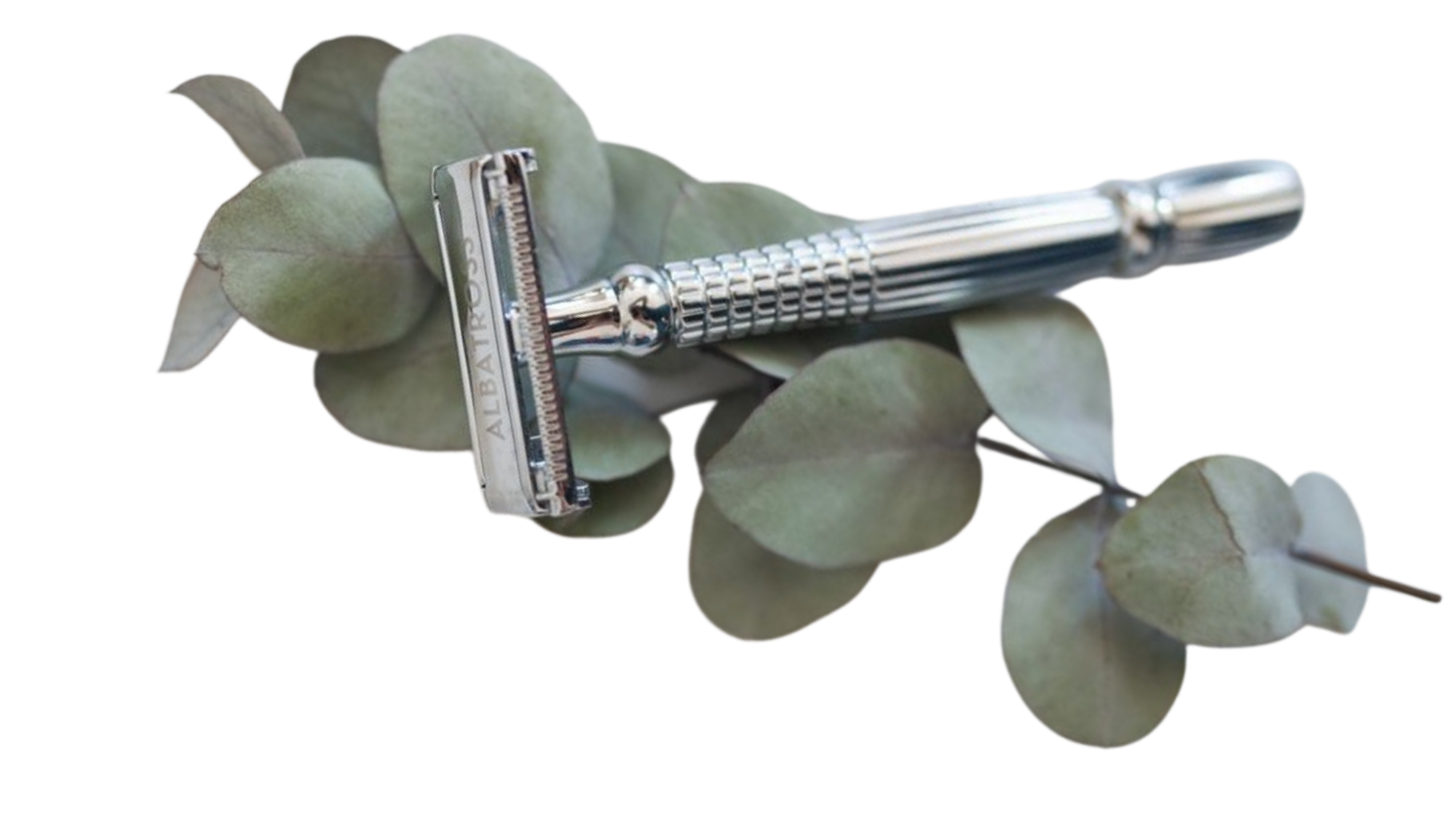 Limestone Tumbled Mist porcelain mosaic tile banner featuring soft grey square tiles with irregular tumbled edges, styled with a silver safety razor and eucalyptus leaves.