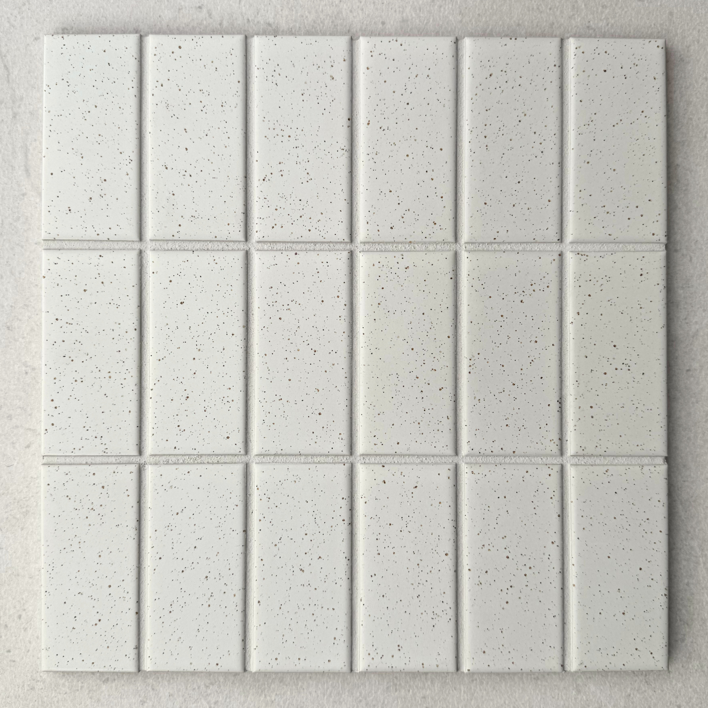 Rasa TimTam Off White porcelain mosaic tile sheet featuring rectangular tiles arranged vertically in a grid, with softly rounded edges and fine dark speckling.