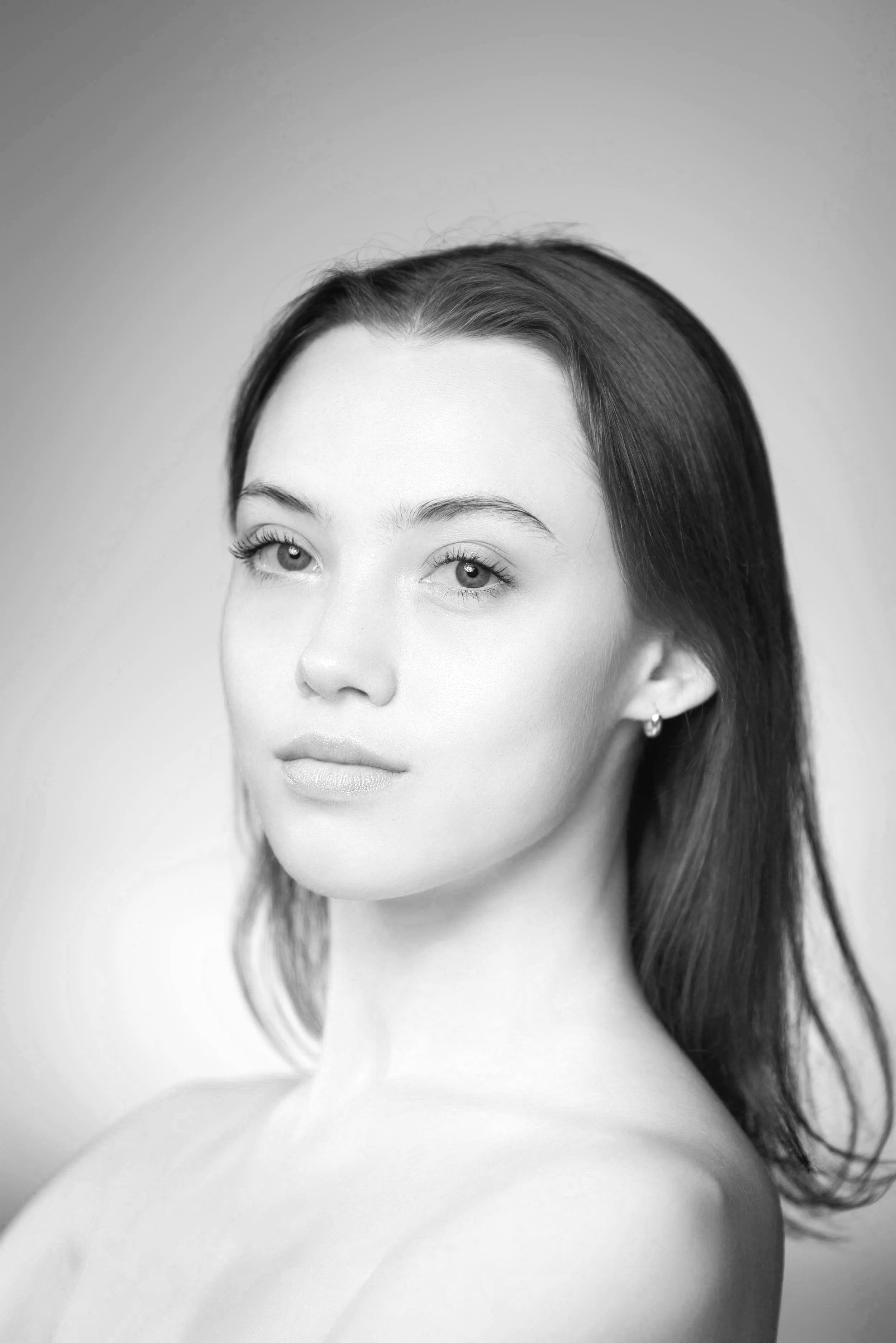 Black and white portrait of a woman with long hair, smooth skin, and light-colored eyes.