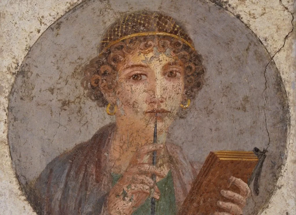 Ancient painting of woman holding a stylus and writing tablet, from Pompeii