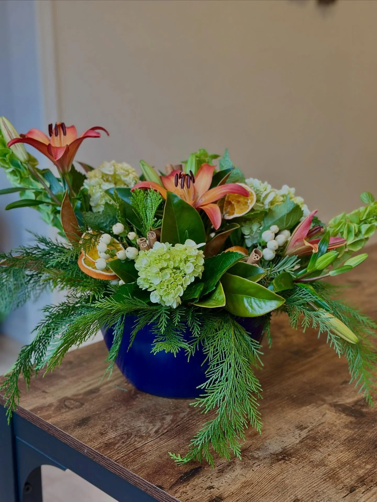 Designed to feel like a quiet winter night by the fire 🔥
This Christmas arrangement blends magnolia leaves, fragrant cedar, orange lilies, white hypericum berries, and mini hydrangeas, with cinnamon sticks and dried oranges for a touch of old-world 