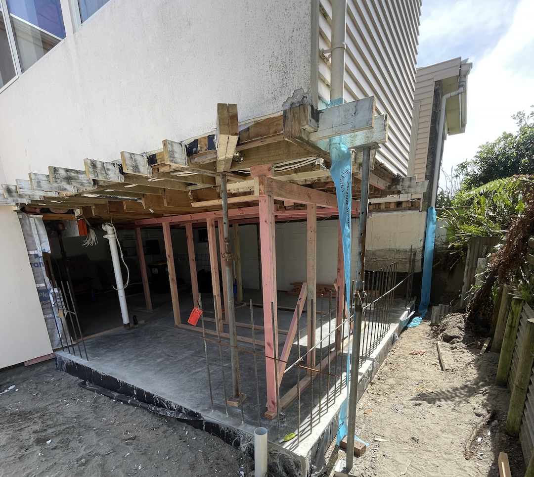 Construction site of a house extension with framing and scaffolding in place.