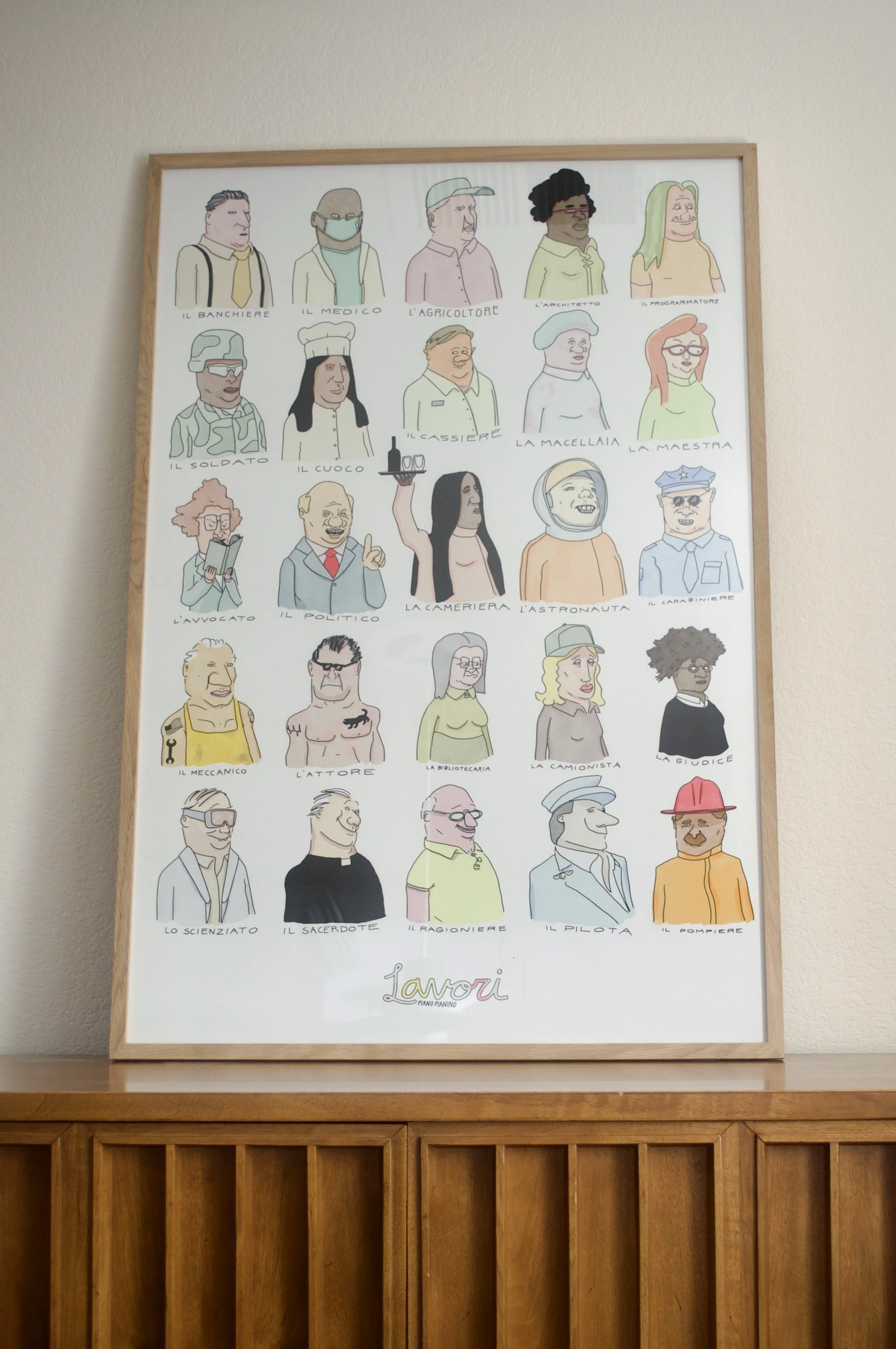 Wall display of Lavori Italian jobs poster by Piano Pianino with illustrated Italian profession words like medico, cuoco, astronauta, meccanico, and pilota
