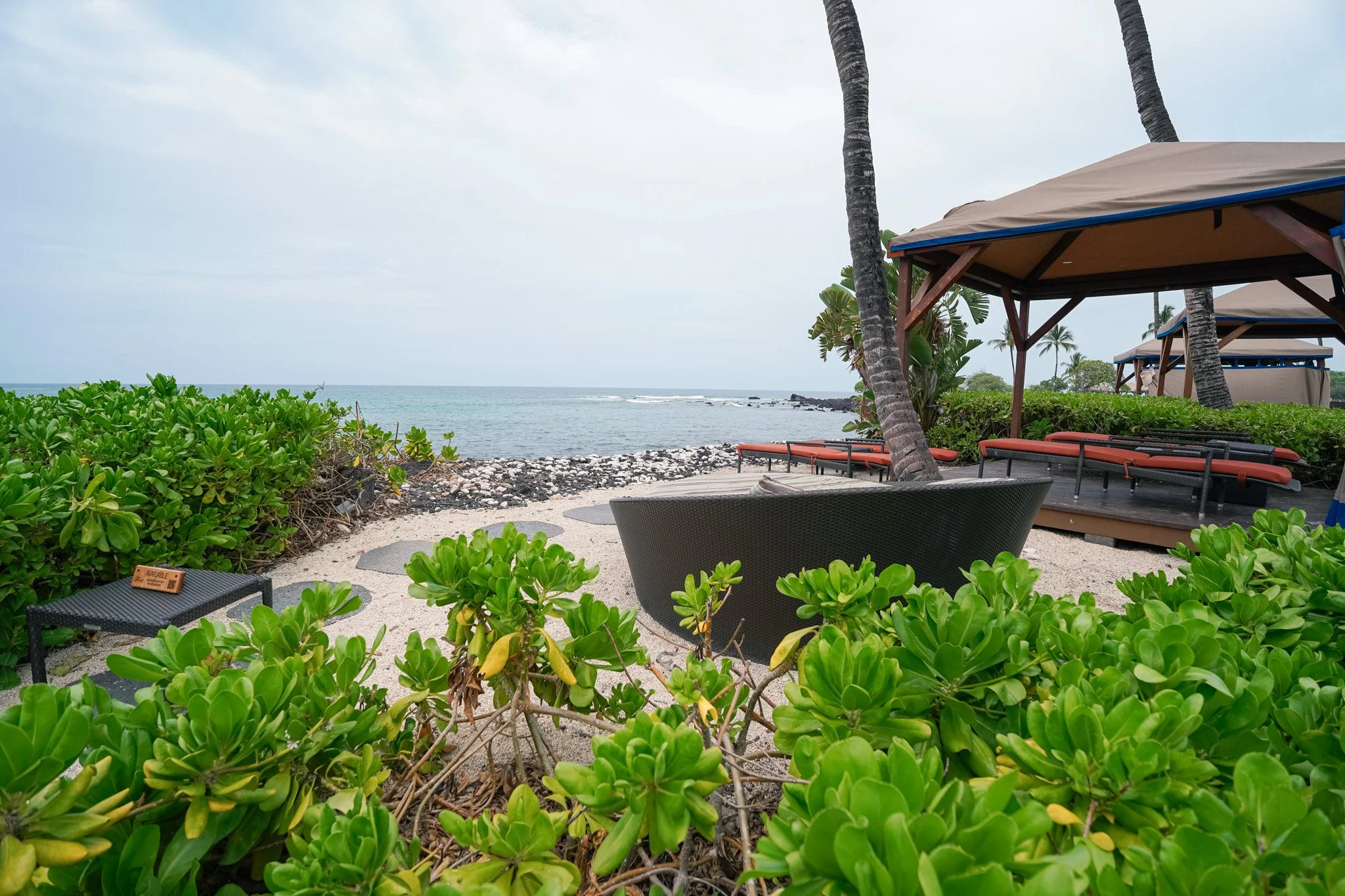 Oceanfront cabana lounge area tucked into the naupaka near the Fairmont Orchid beach
