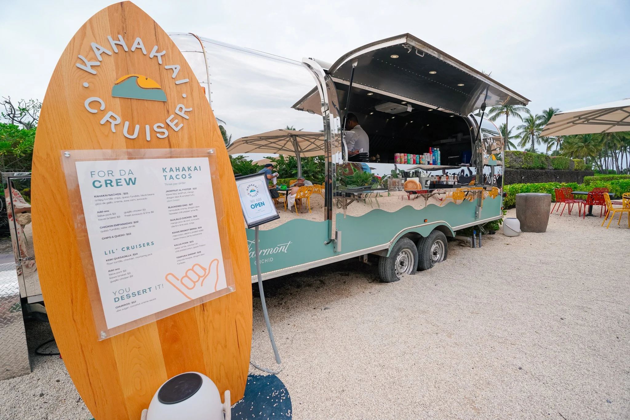 The Kahakai Cruiser Airstream taco truck with a surfboard-shaped menu board near Pauoa Bay