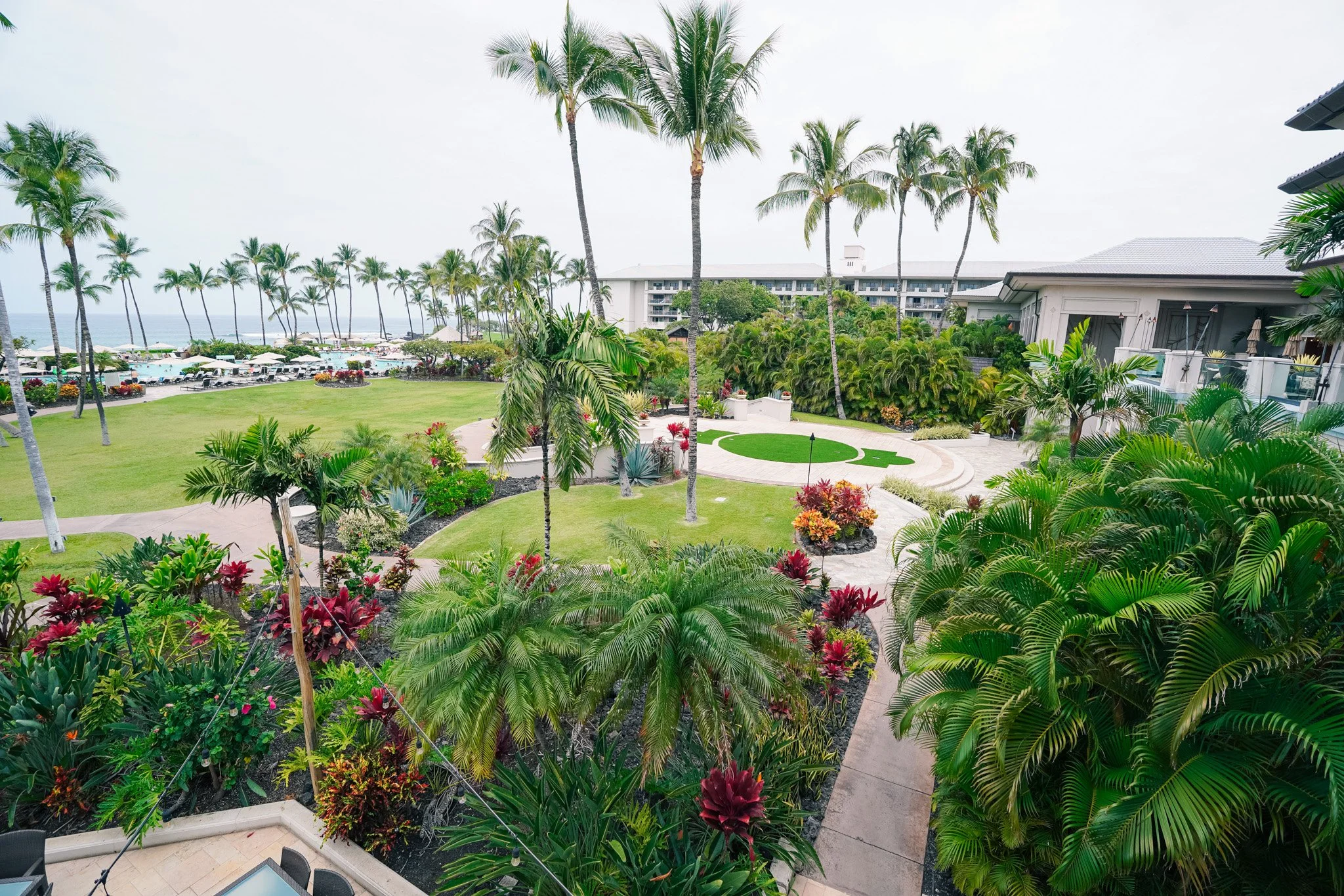 Wide view of the Fairmont Orchid property with open lawns, palm trees, and the ocean in the distance