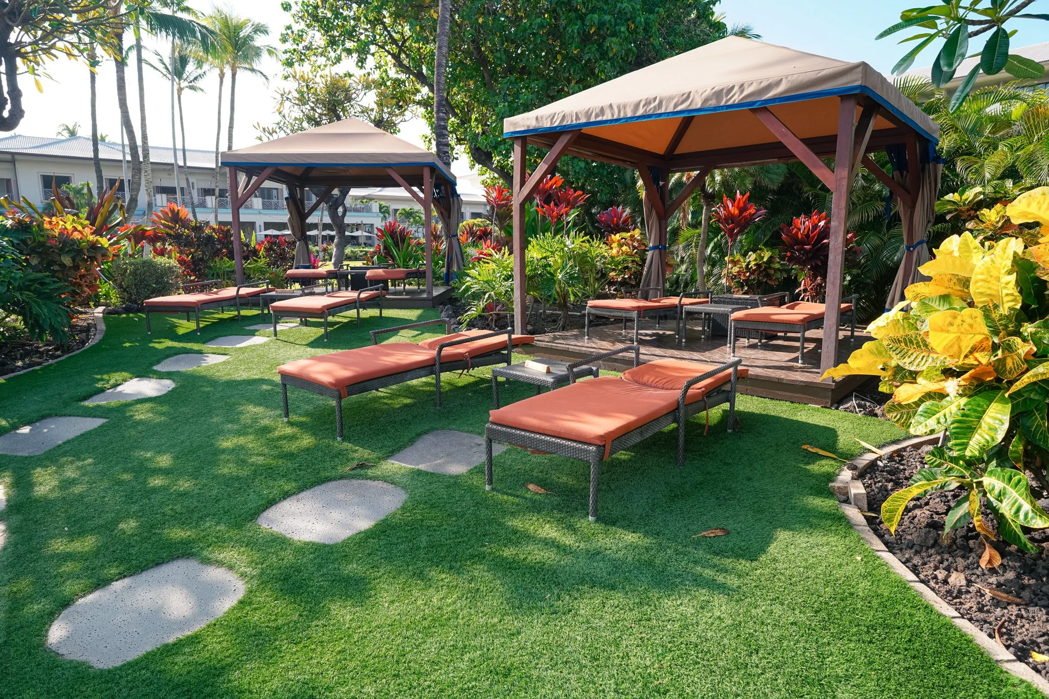 Our reserved cabana setup on the lawn at the Fairmont Orchid with orange-cushioned lounges