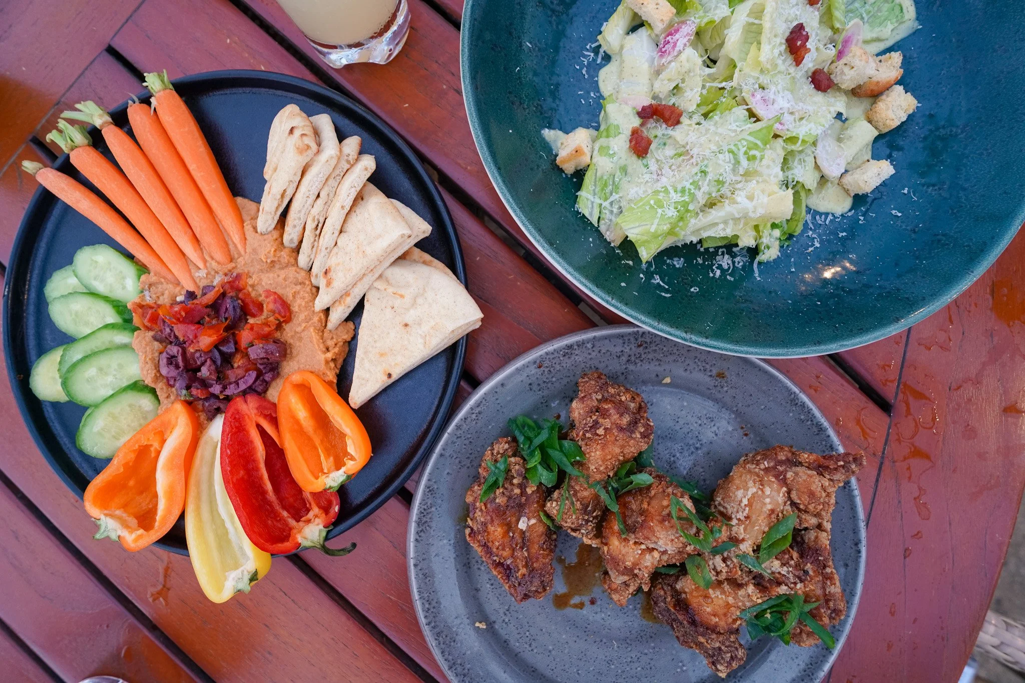 Mochiko-style chicken wings, hummus platter, and caesar salad at Hale Kai