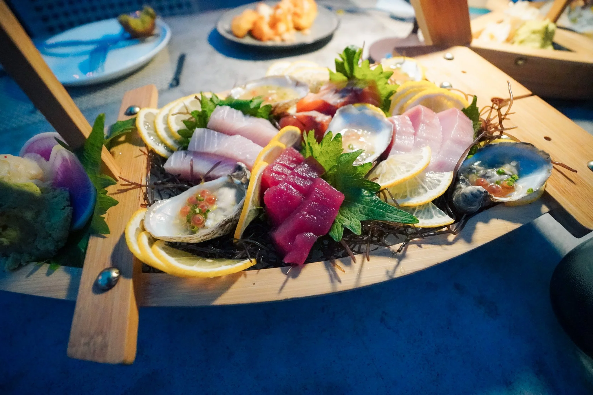 A large sashimi boat at Binchotan featuring fresh local tuna, hamachi, and yuzu oysters
