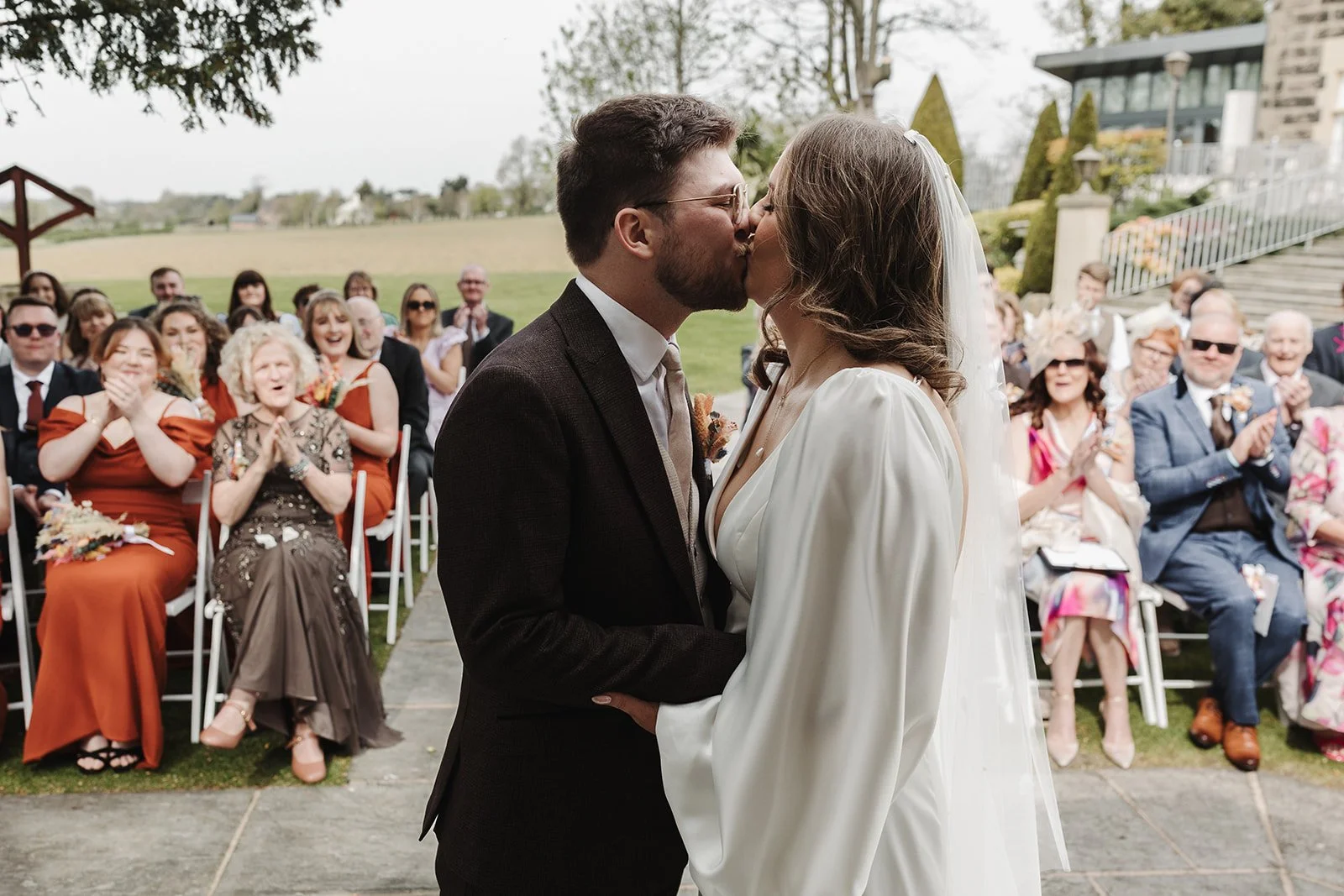 The bride and groom kissing after their outdoor wedding ceremony at West Tower, Lancashire, Aughton