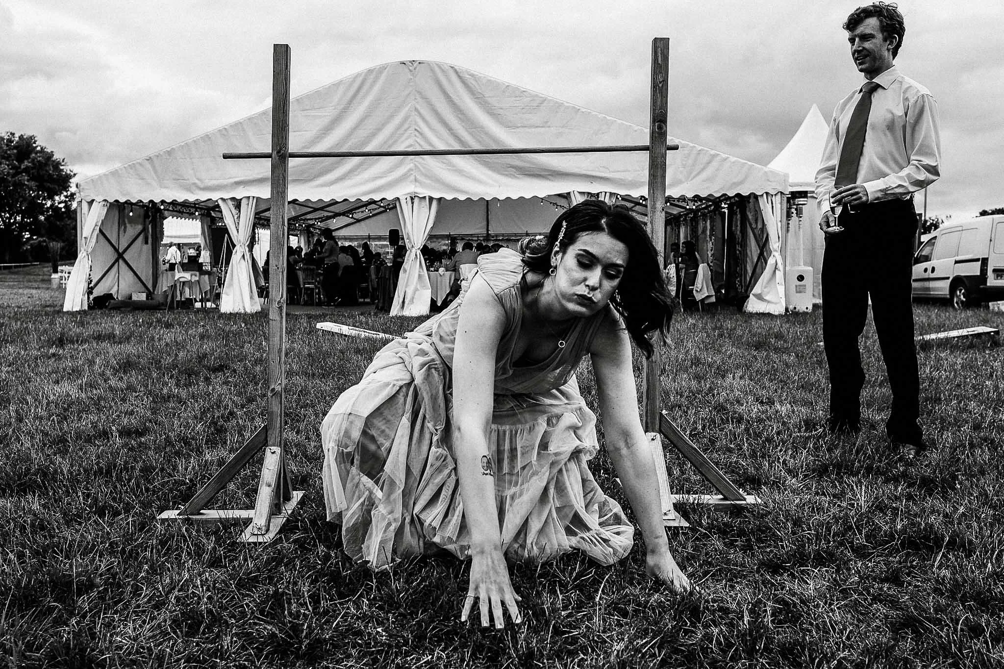 a photograph of a bridesmaids just about making it when playing limbo.