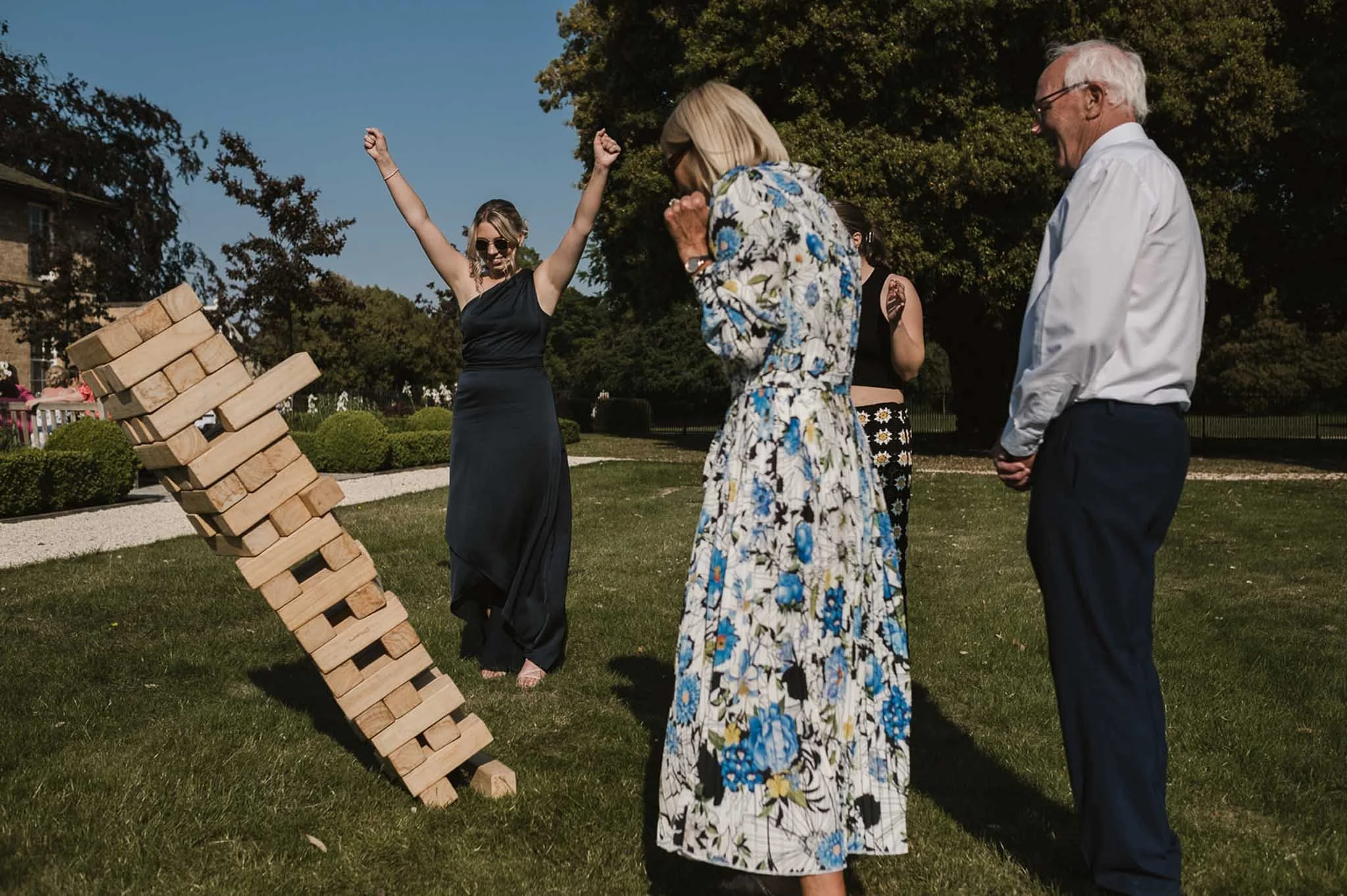 A photograph of wedding guests playing giant jenga on the lawn