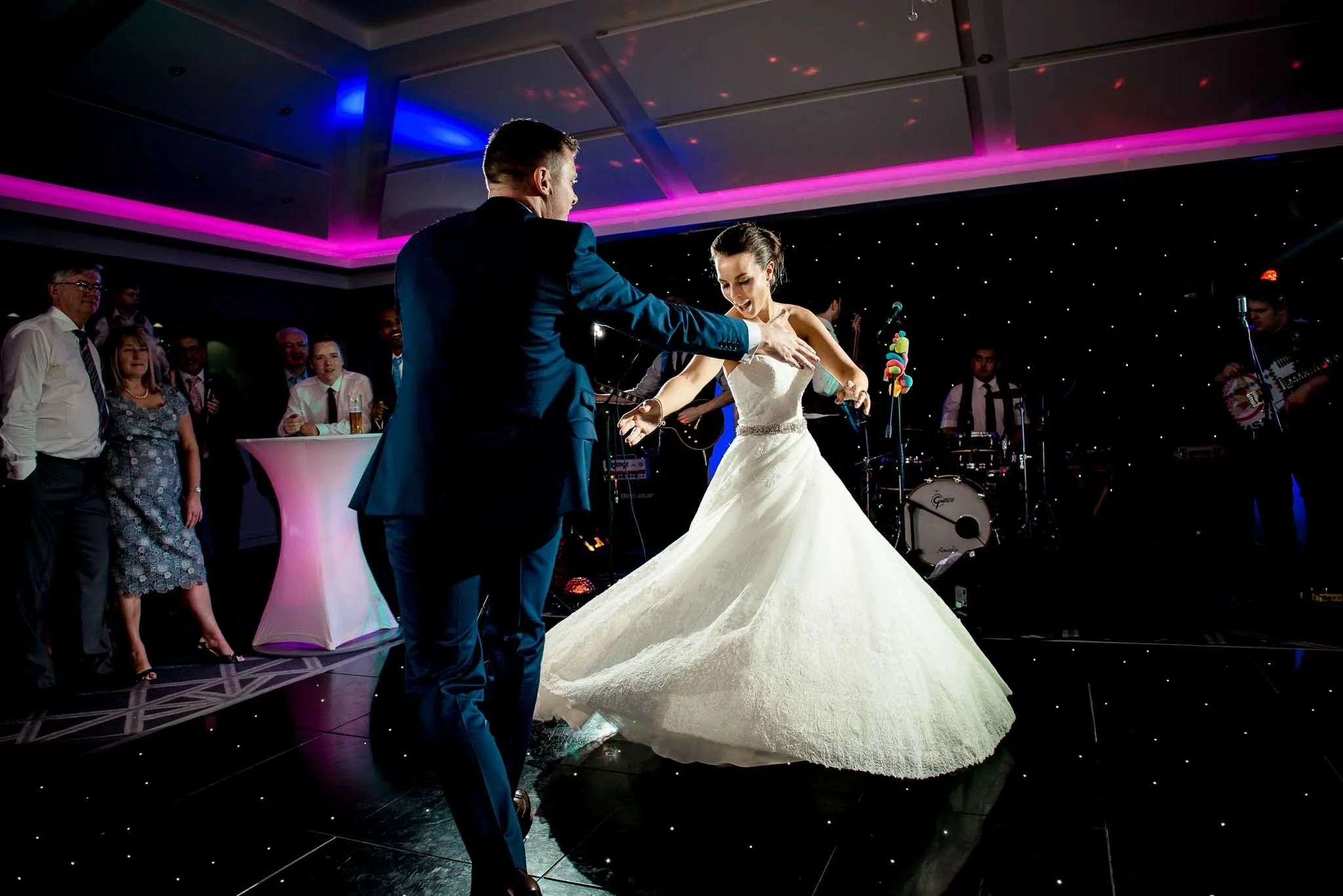 bride and groom dancing on the dance floor with the brides wedding dress swooshing from side to side.