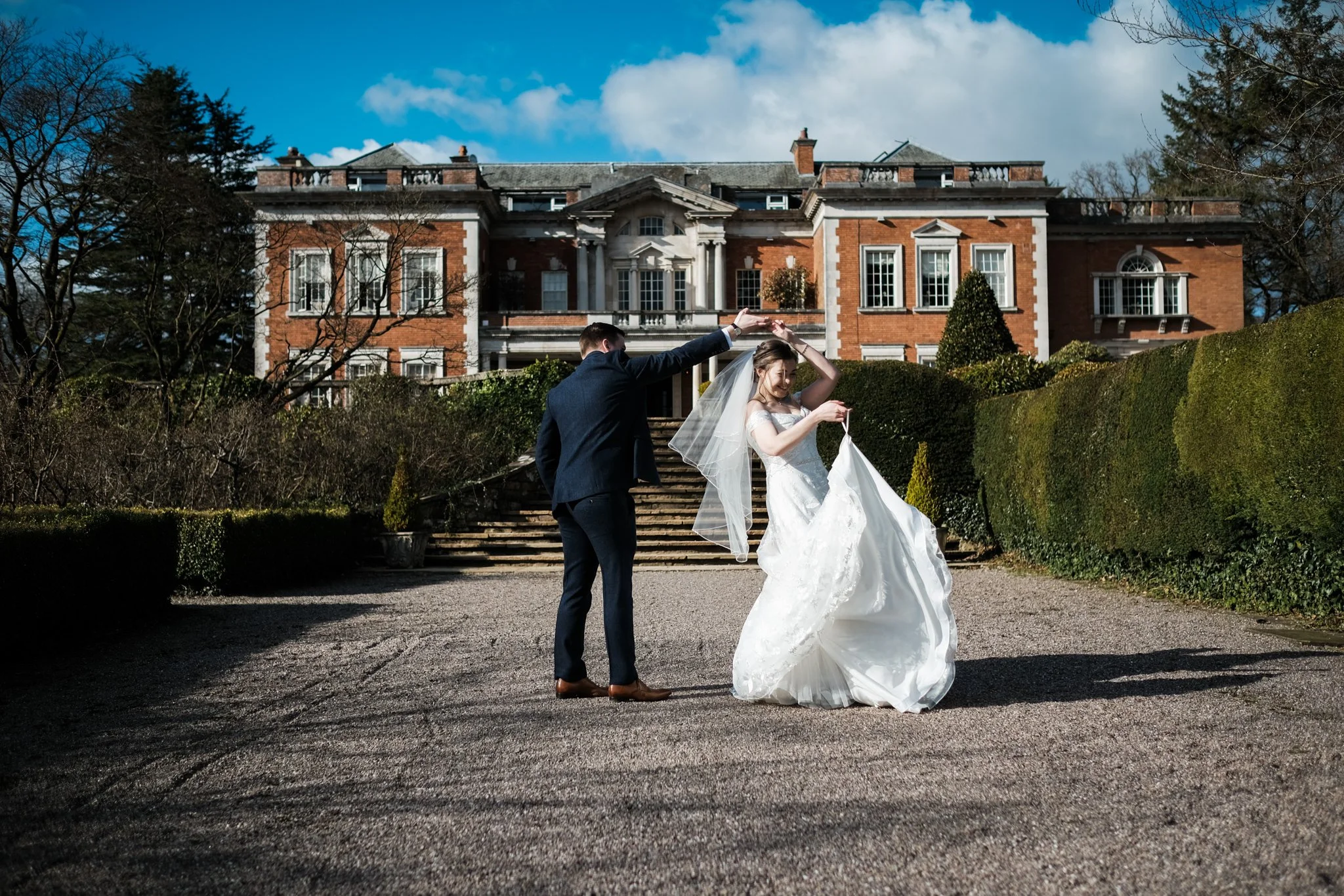 Bride and Groom dancing with excitement. The bride purchased her wedding dress from a wedding dress shop near Liverpool Alexander Wedding Co.