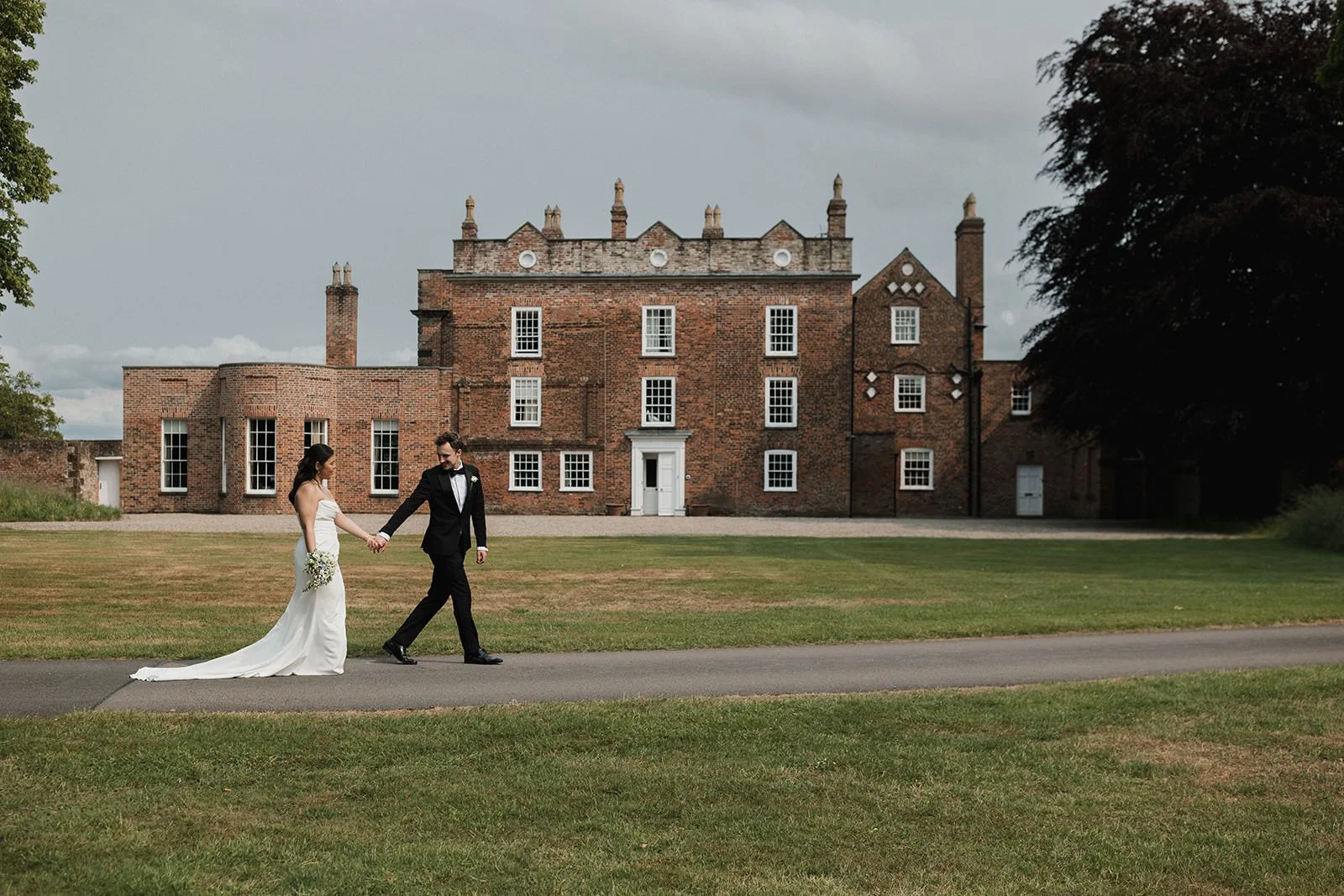 Meols Hall Wedding Photography showing the couple strolling past the main house.