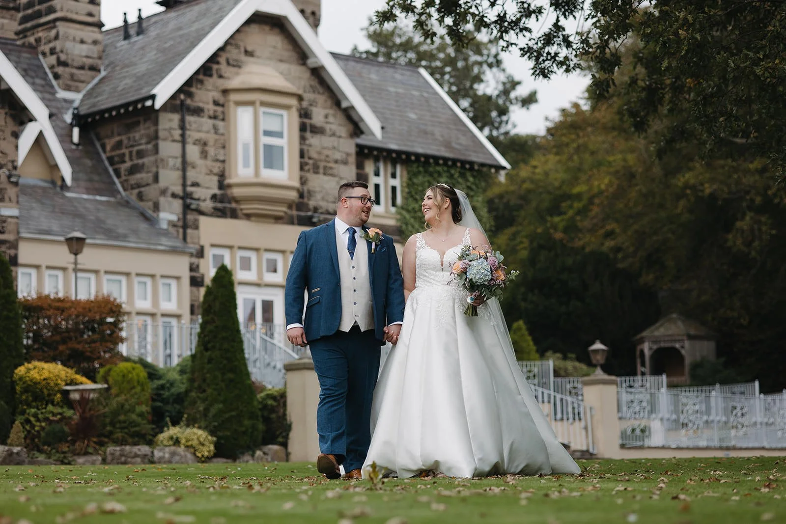 Bride and groom walking through the landscaped grounds at West Tower, Lancashire, Aughton