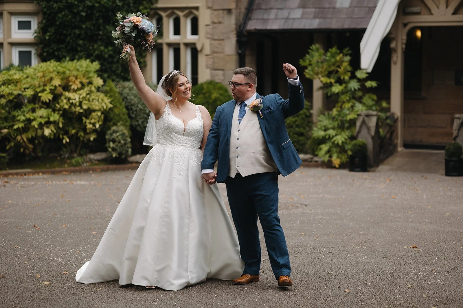 bride and groom fist pumping the air in celebration