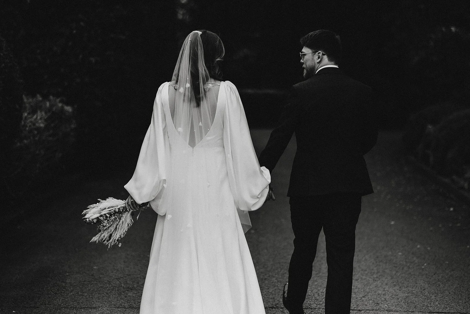 bride and groom walking across the grounds at west Tower, after visiting our bridal boutique in Formby near Liverpool.