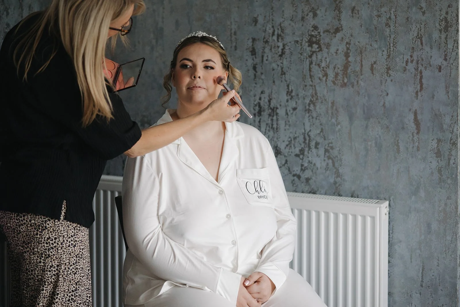 A wedding photograph showing a bride getting ready at west tower in the crystal suite.