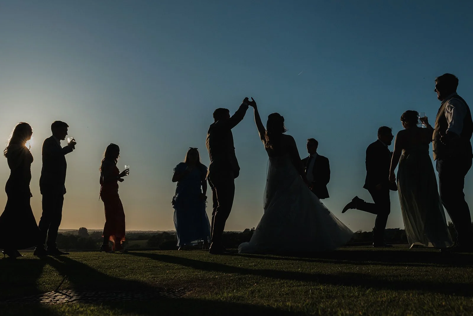 wedding guest dancing on the lawn during golden hour at West Tower