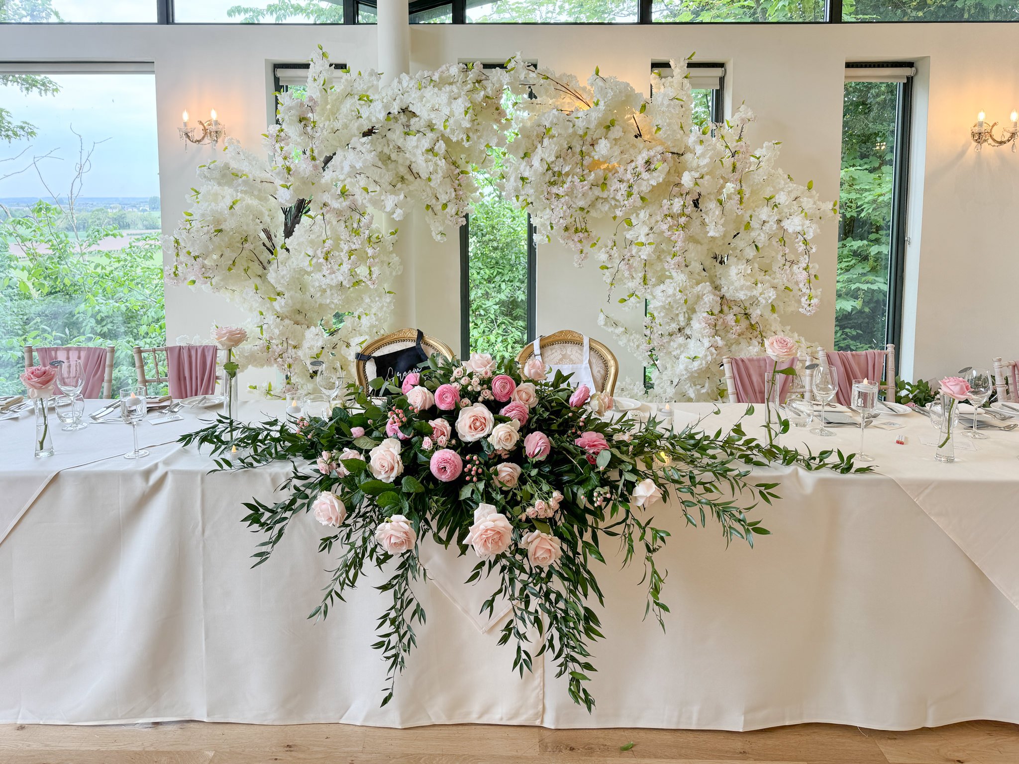 Wedding styling at West Tower using fresh pink flowers and ivory blossom arch.