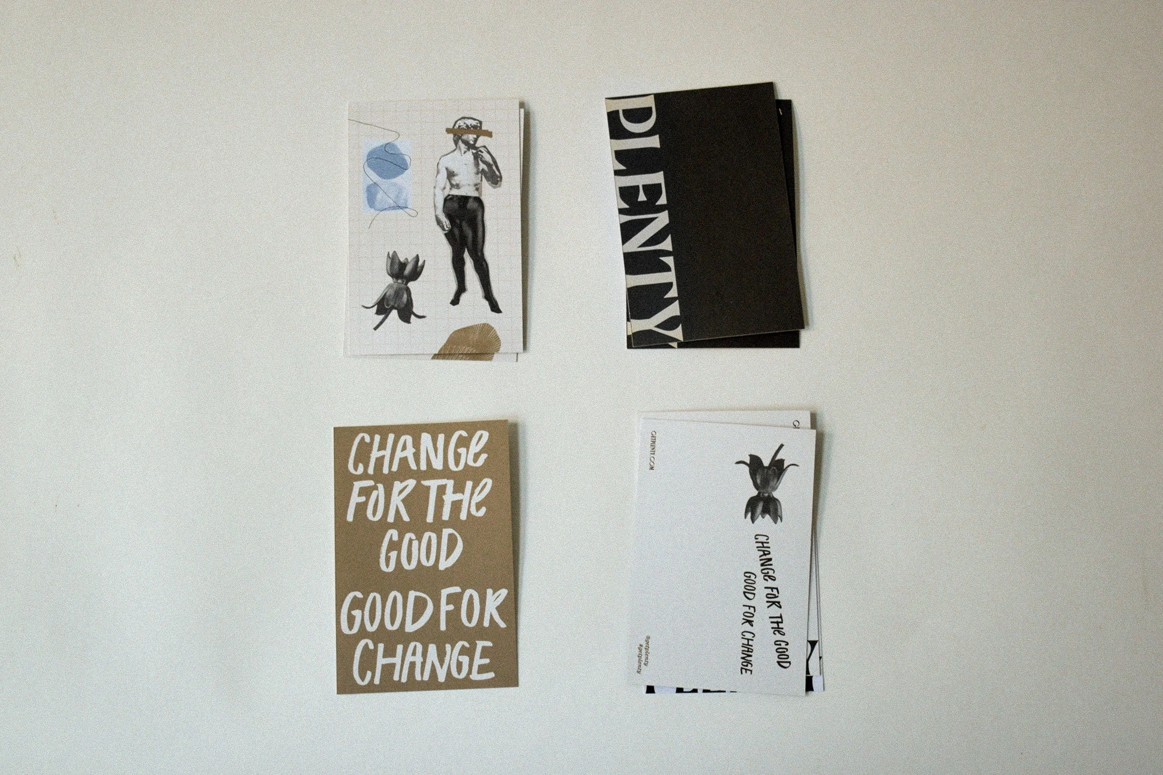 Four printed materials arranged on a white surface, including illustrations, text, and photographs, with motivational and artistic themes.