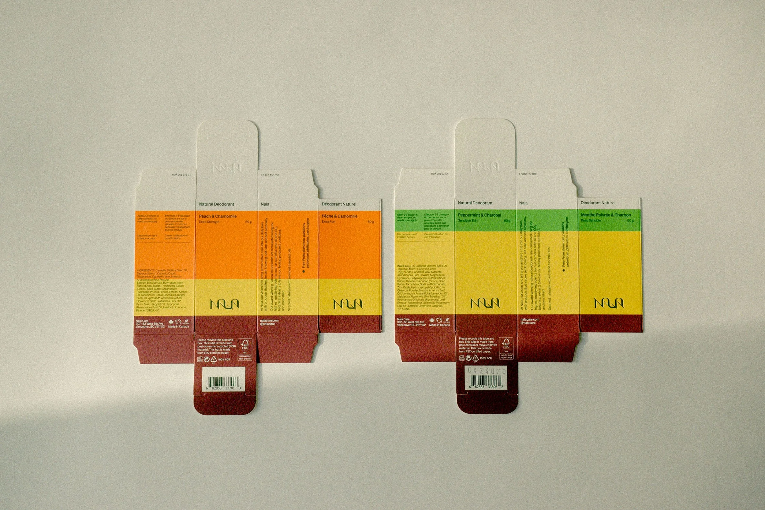 Two boxes of natural deodorant, one with peach and chamomile scent and the other with peppermint and charcoal scent, laid flat on a light-colored surface.