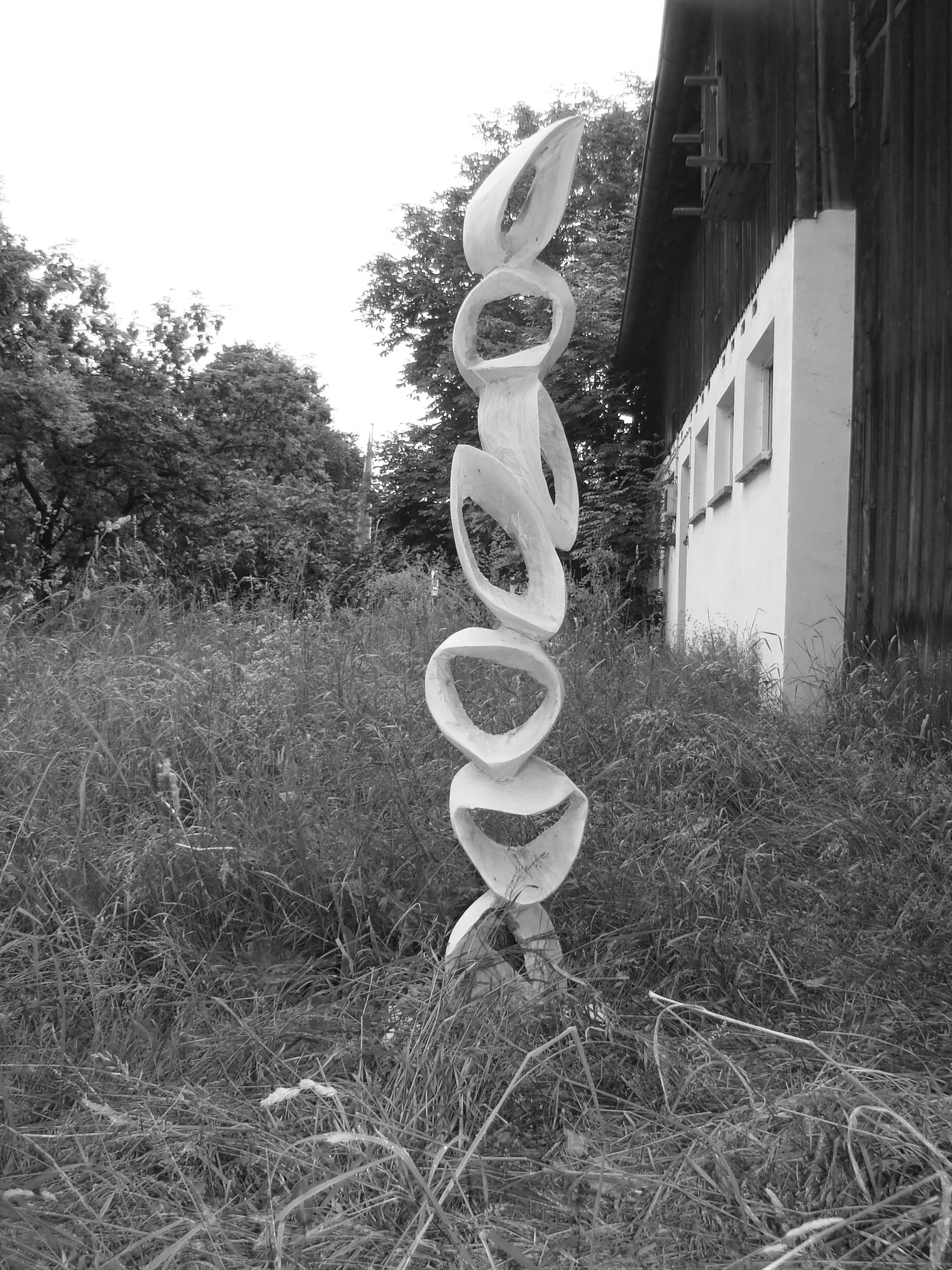 Ein vertikaler Holzskulptur mit mehreren ovalen und geschwungenen Formen Kunst Christopher Bazylak Heidelberg