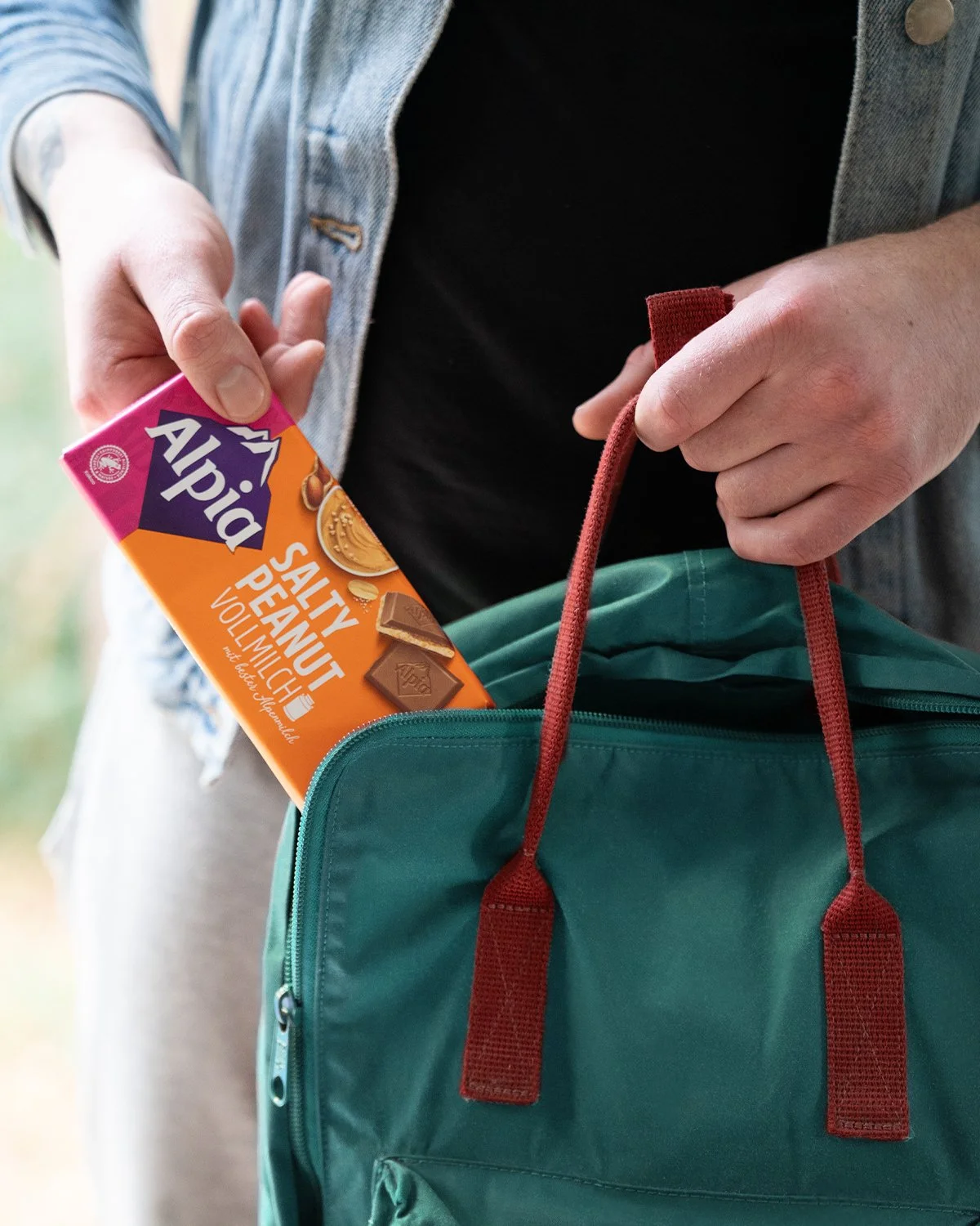 Alpia Salty Peanut Tafel in dem Rucksack – Der perfekte süß-salzige Snack für unterwegs, griffbereit für spontane Genussmomente.