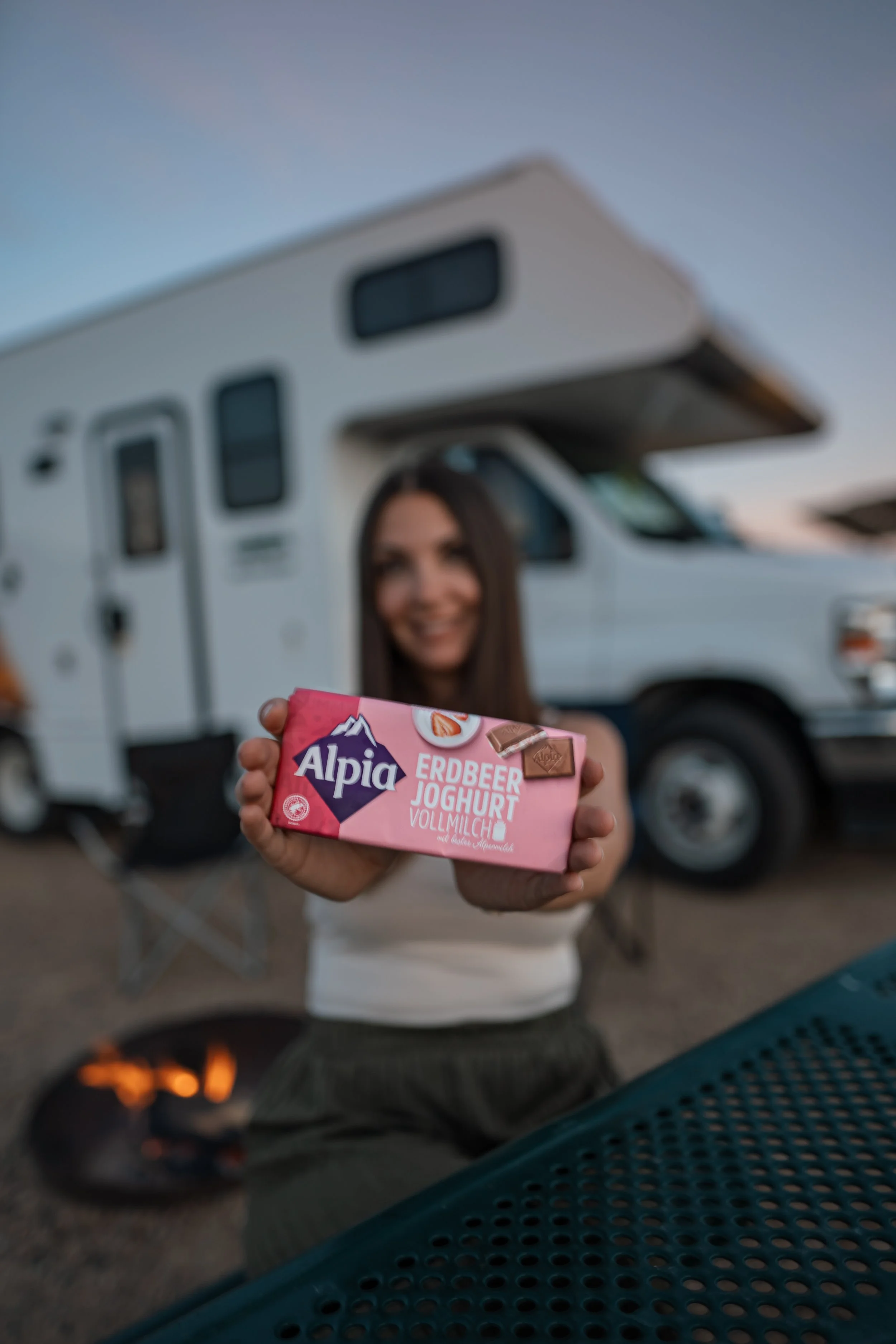 Alpia Erdbeer-Joghurt Tafel im Nahaufnahme – Cremiger Schokoladengenuss in sommerlicher Camper-Atmosphäre mit Fokus auf Detail und Textur.