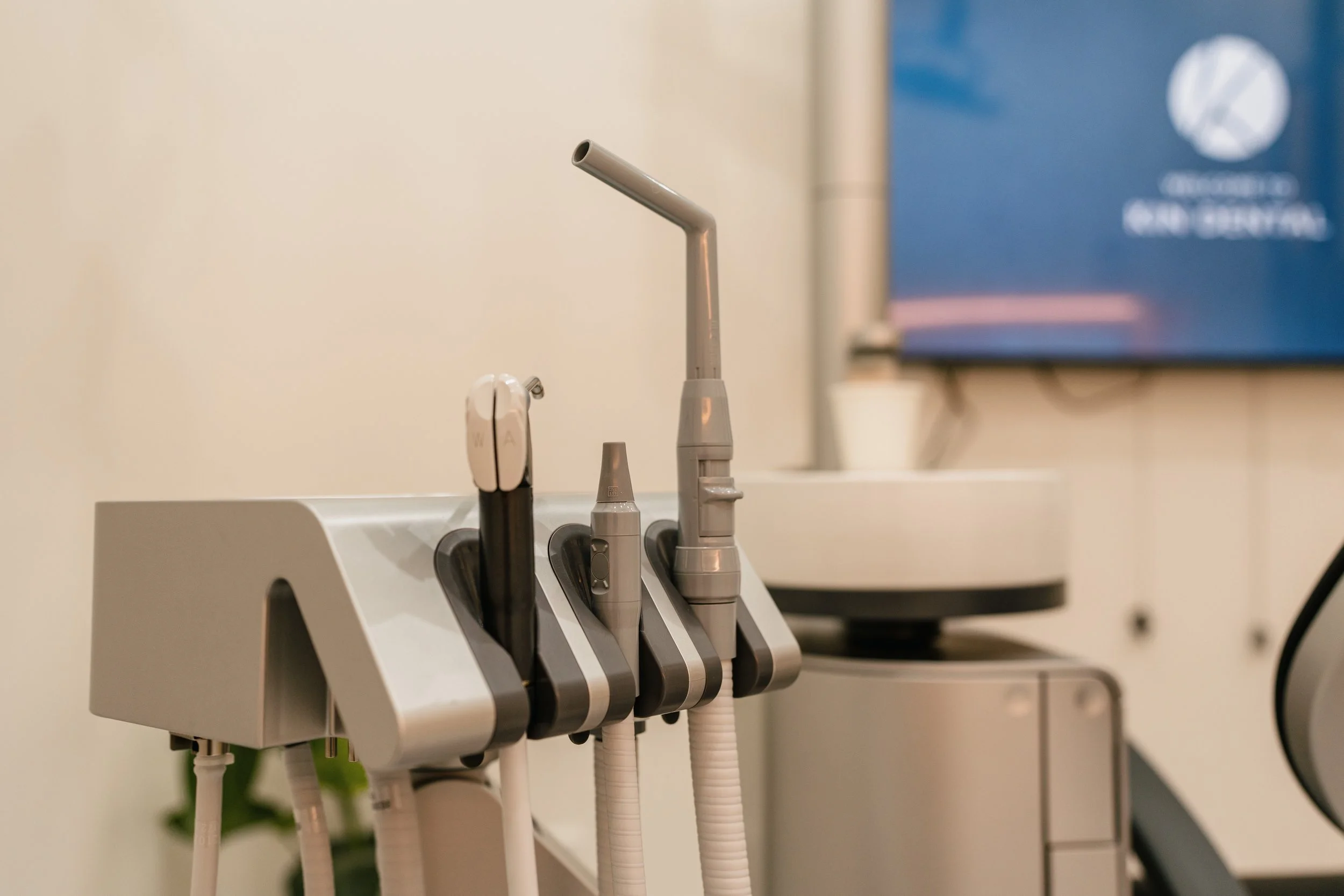 Dental equipment with various handpiece tools on a tray in a dental office.