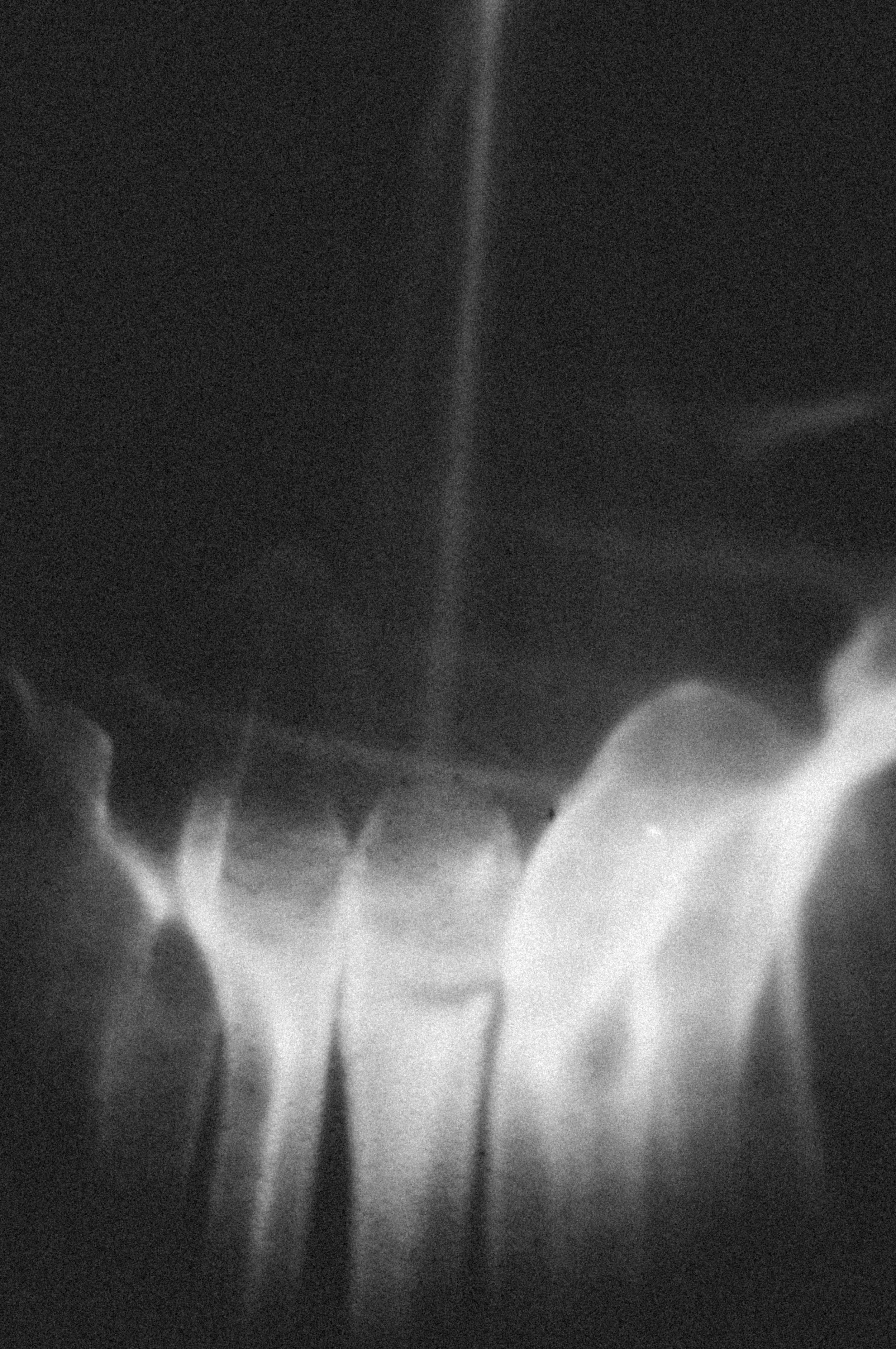 Abstract black and white image with flowing, smoky shapes and light streaks.