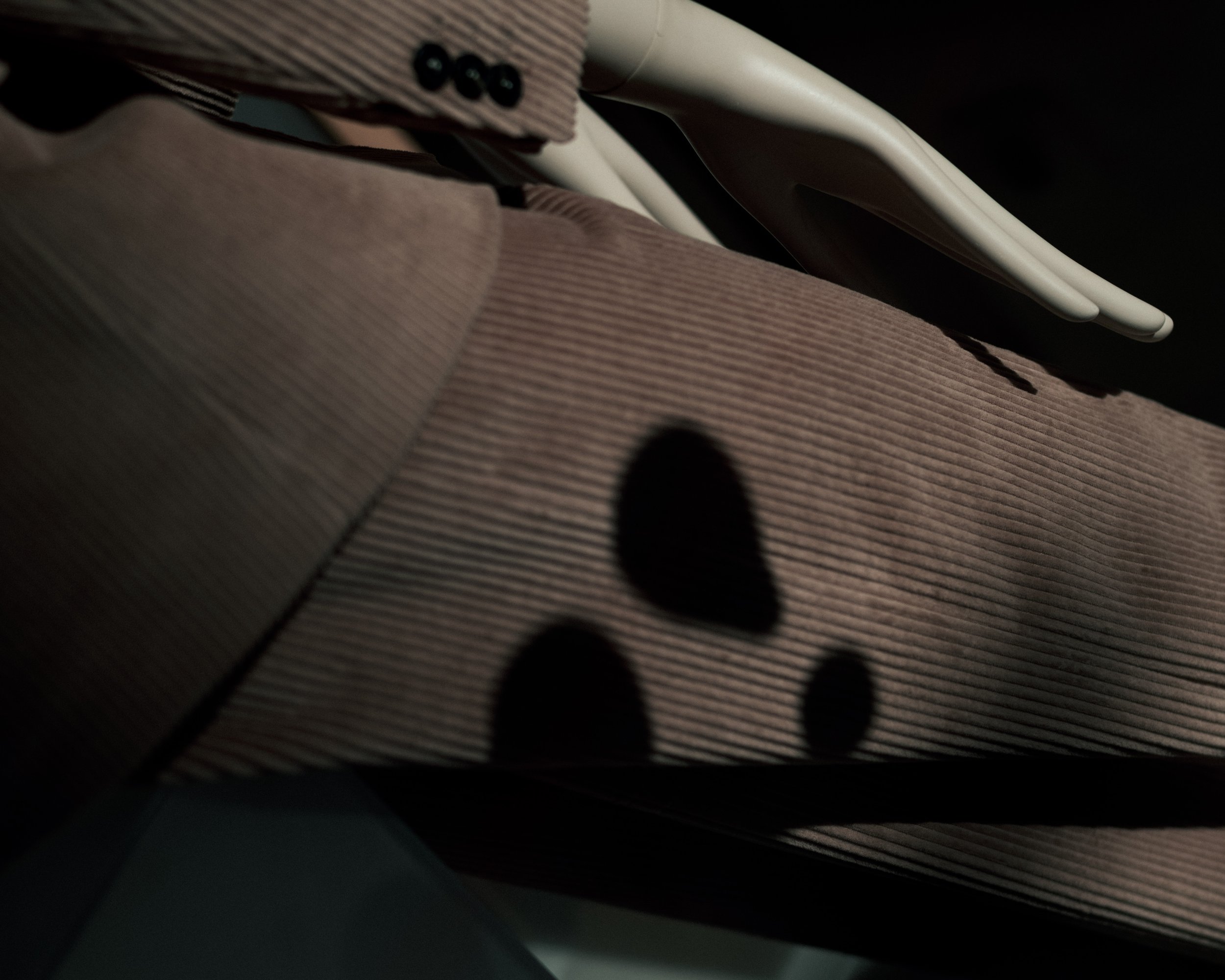 Close-up of a fabric bag with black floral pattern, partially covering a white plastic object, on a dark surface.