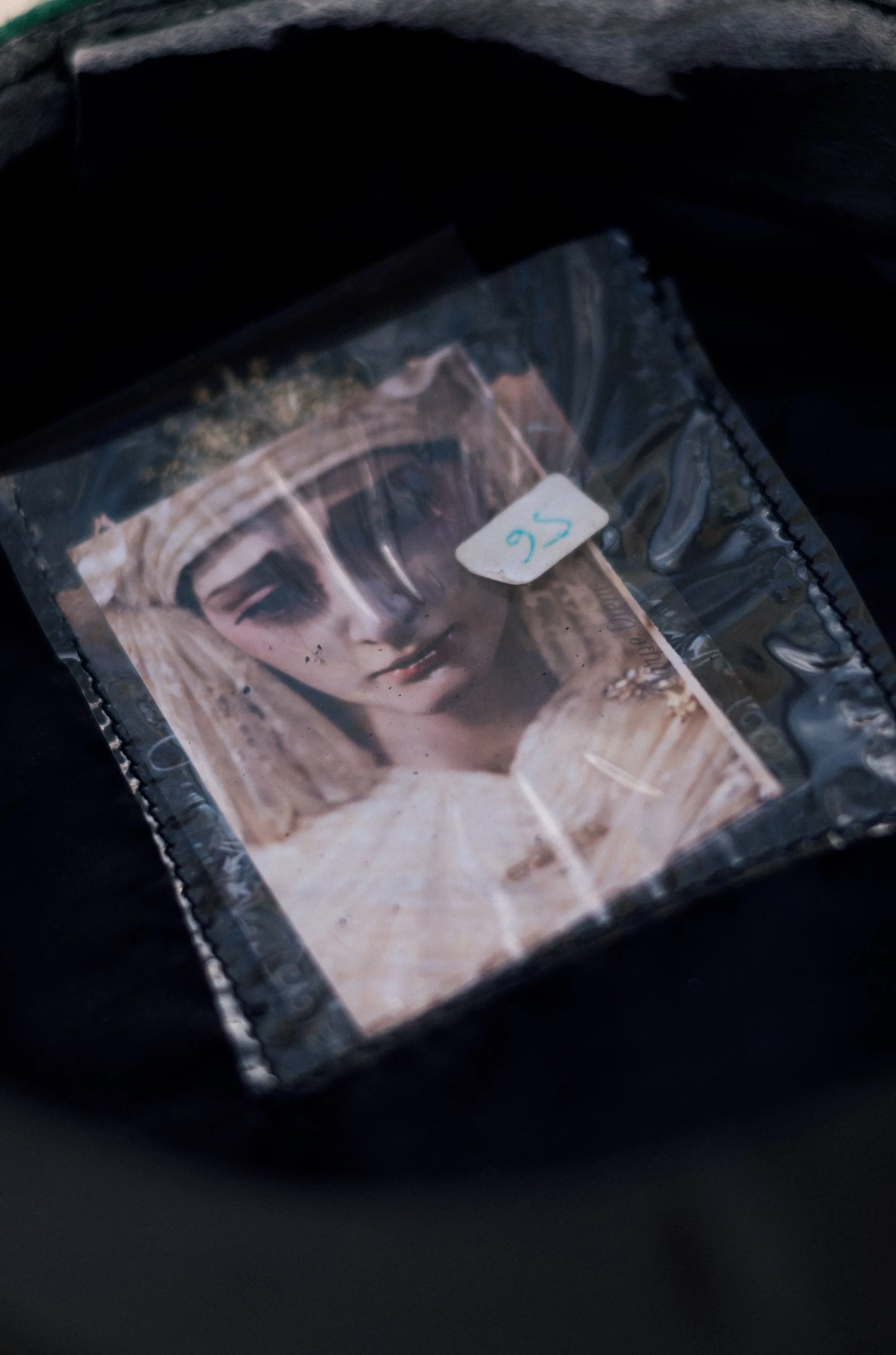 A small plastic bag containing a religious icon image of the Virgin Mary with a white sticker marked 'S6' attached to it.
