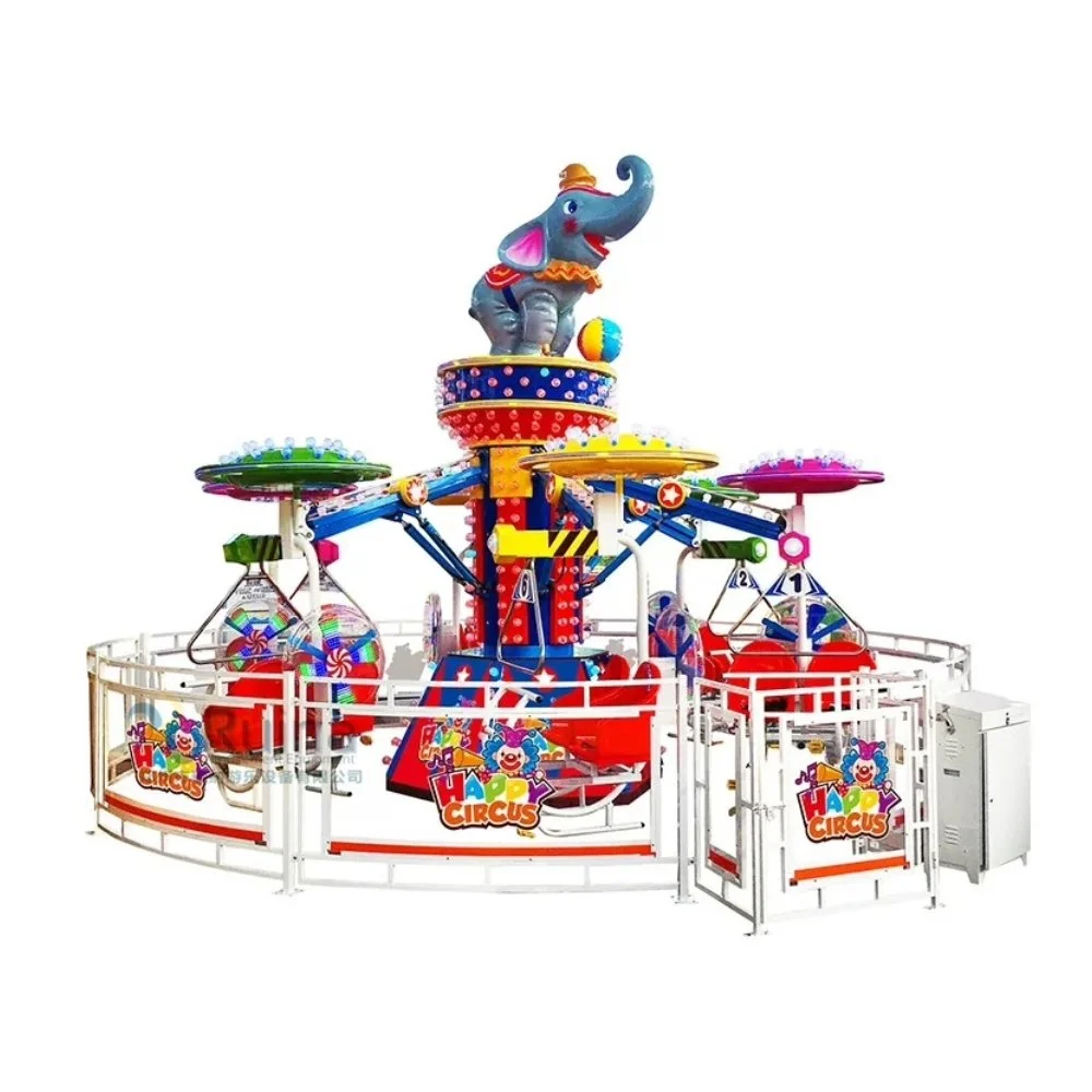 Cavalinho de parque de diversões com elefante azul no topo. Estrutura colorida com vários brinquedos e anúncios de 'Happy Circus' ao redor.