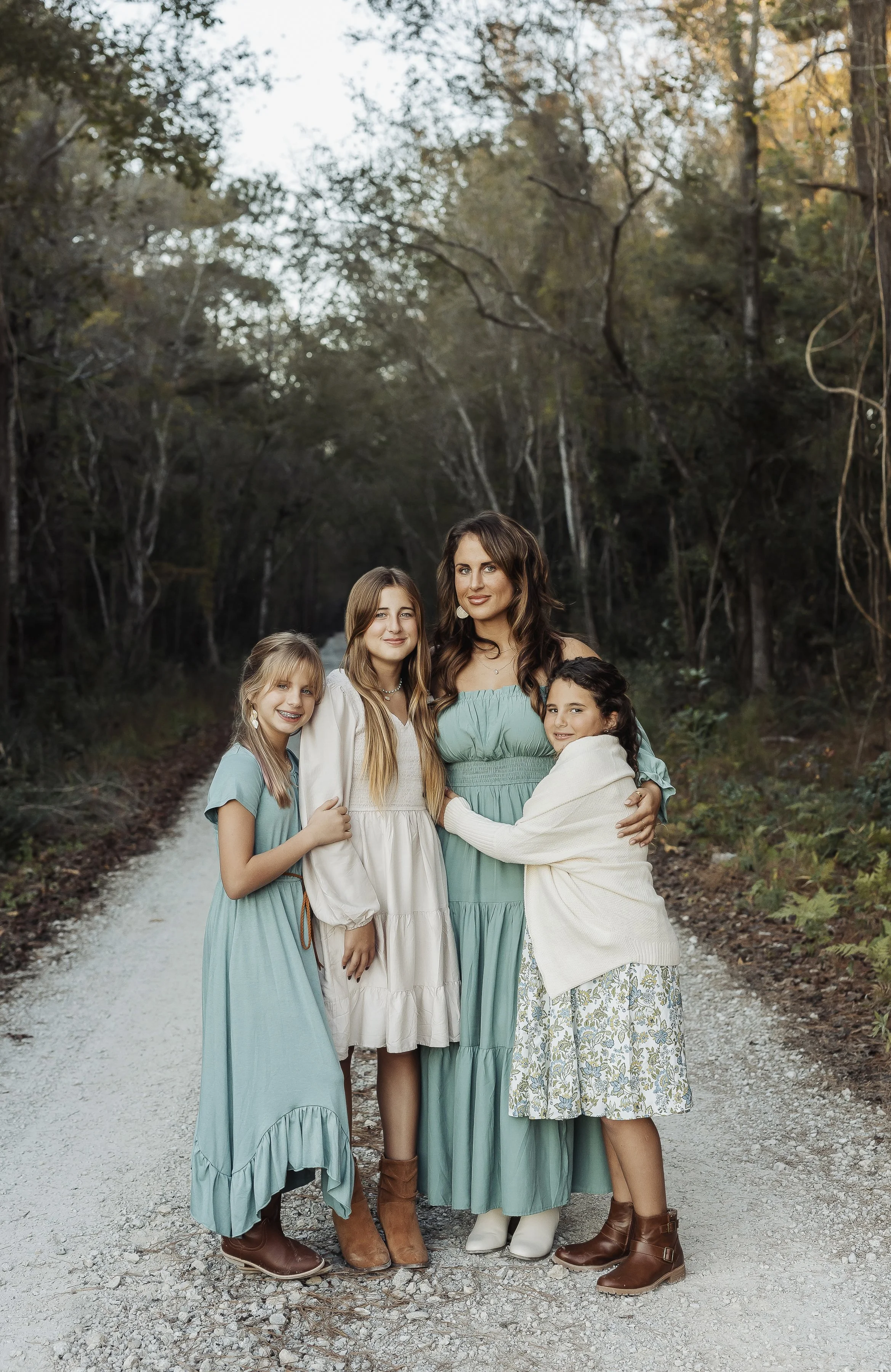 Mother and three daughters in cream and green dresses near the woods capturing beauty and essence in timeless, artful images by Storm Pierre Photography in Jacksonville, Richlands, Hampstead, and Sneads Ferry North Carolina