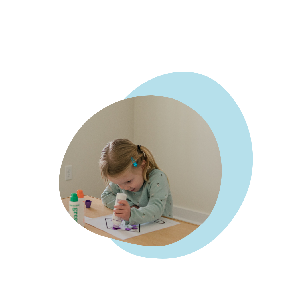 Young child using dot markers on paper at a table
