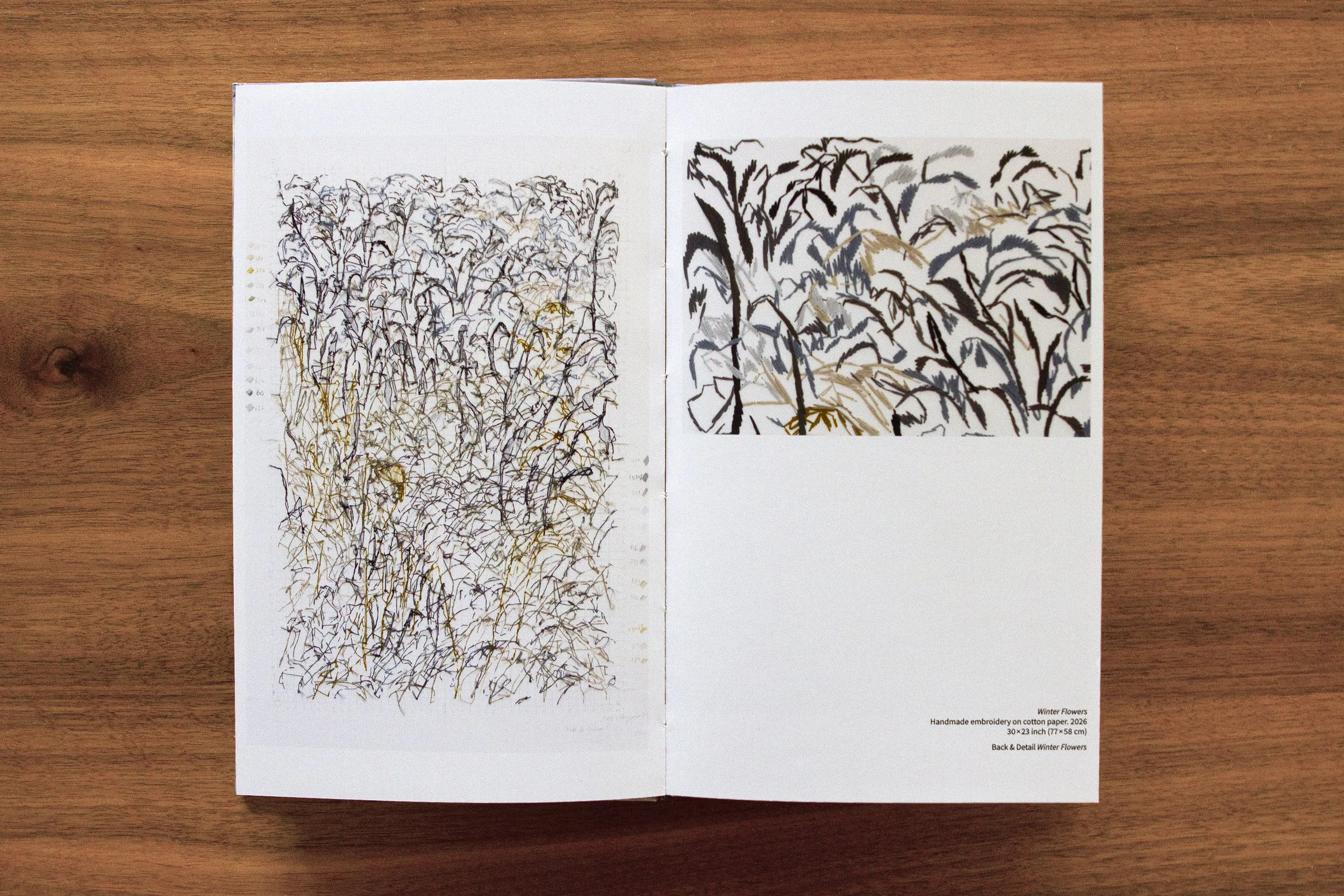 Open booklet displaying an embroidery artwork of winter flowers on the left page and a photo of the embroidery on the right page, with some text describing the artwork details.