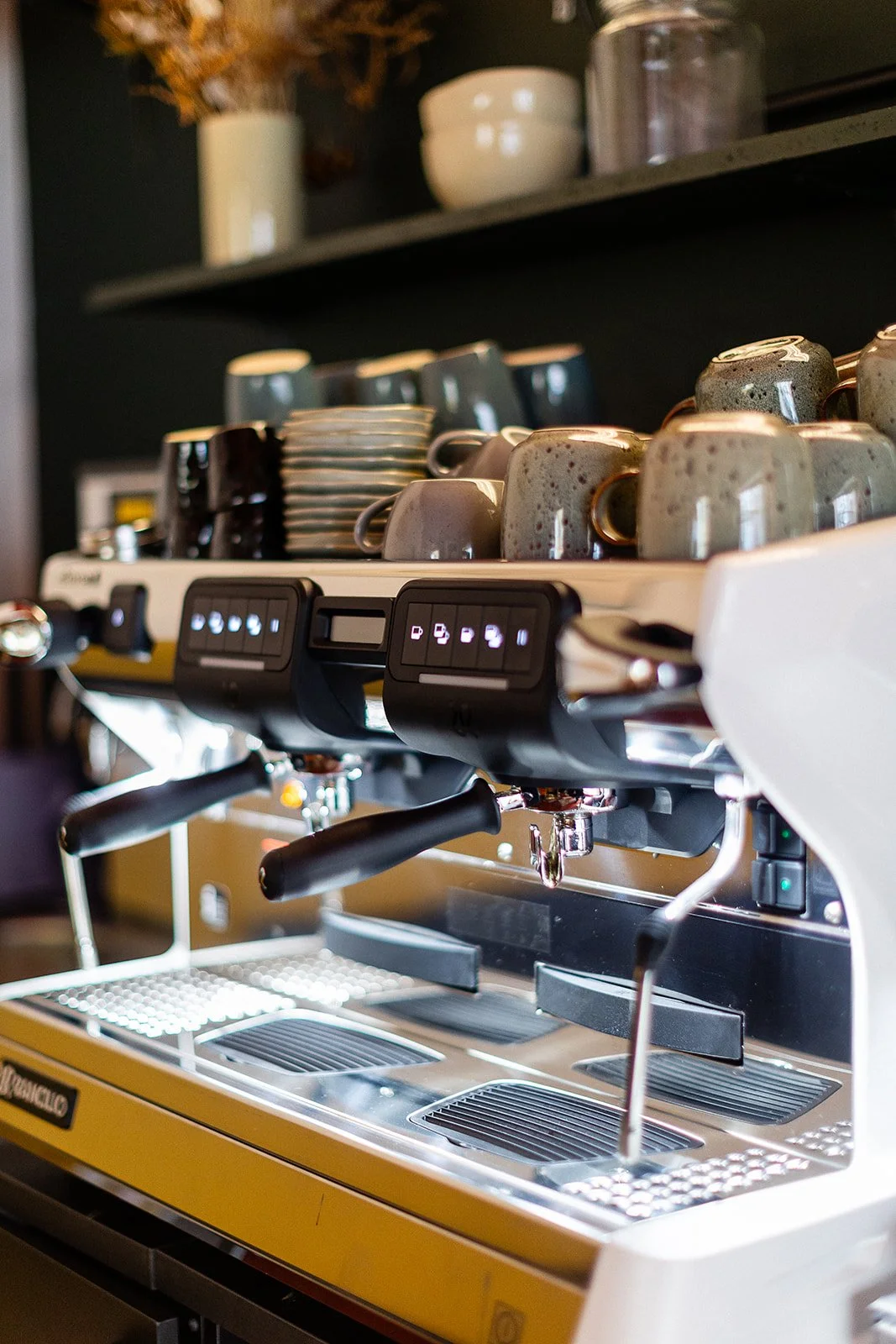 Coffee machine lit up with stoneware cups on top at Front Room coffee shop at The Hide, wedding and events venue, Sheffield.