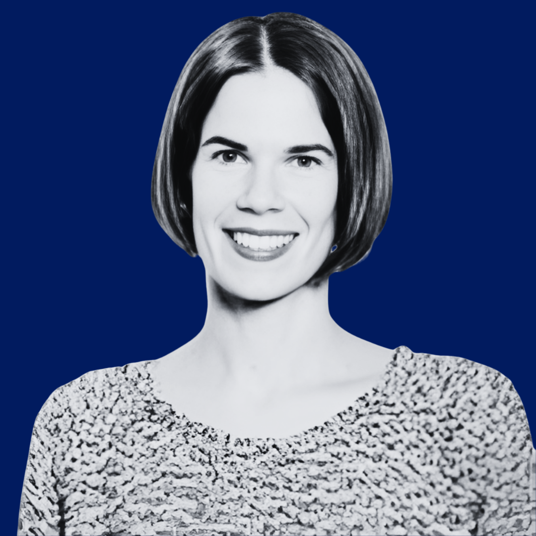 Black and white portrait of a young woman with short hair, smiling, against a solid dark blue background.