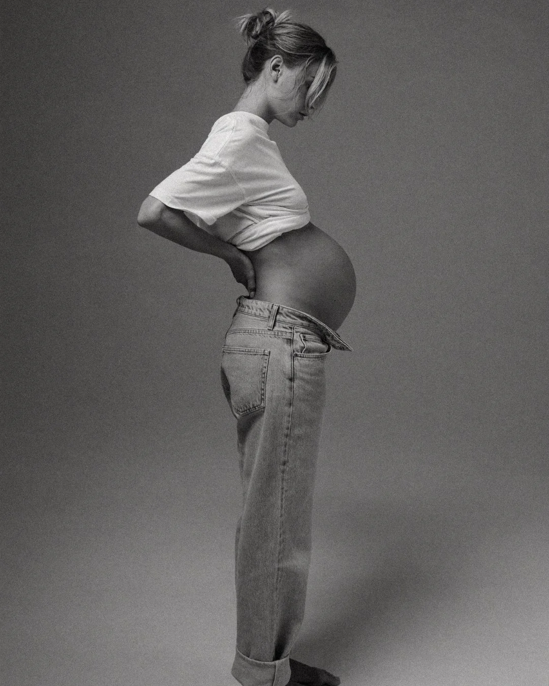 pregnant woman with jeans and showing belly