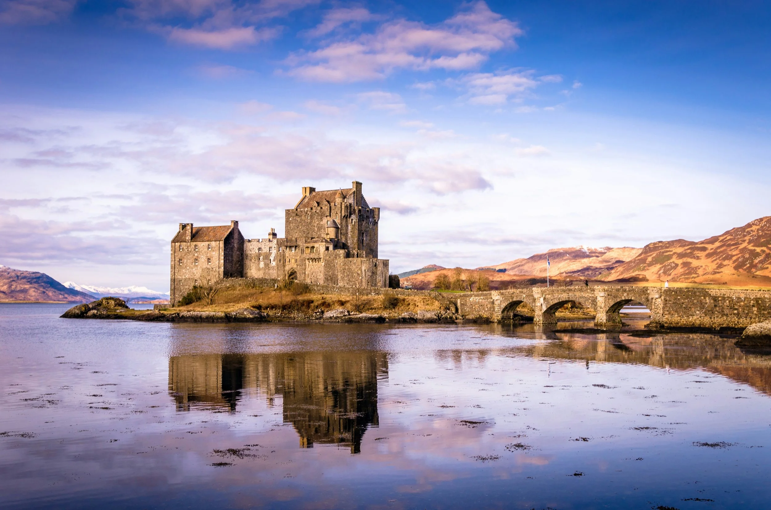 Eilean Donan Castle in spring reflected in calm water in the Scottish Highlands