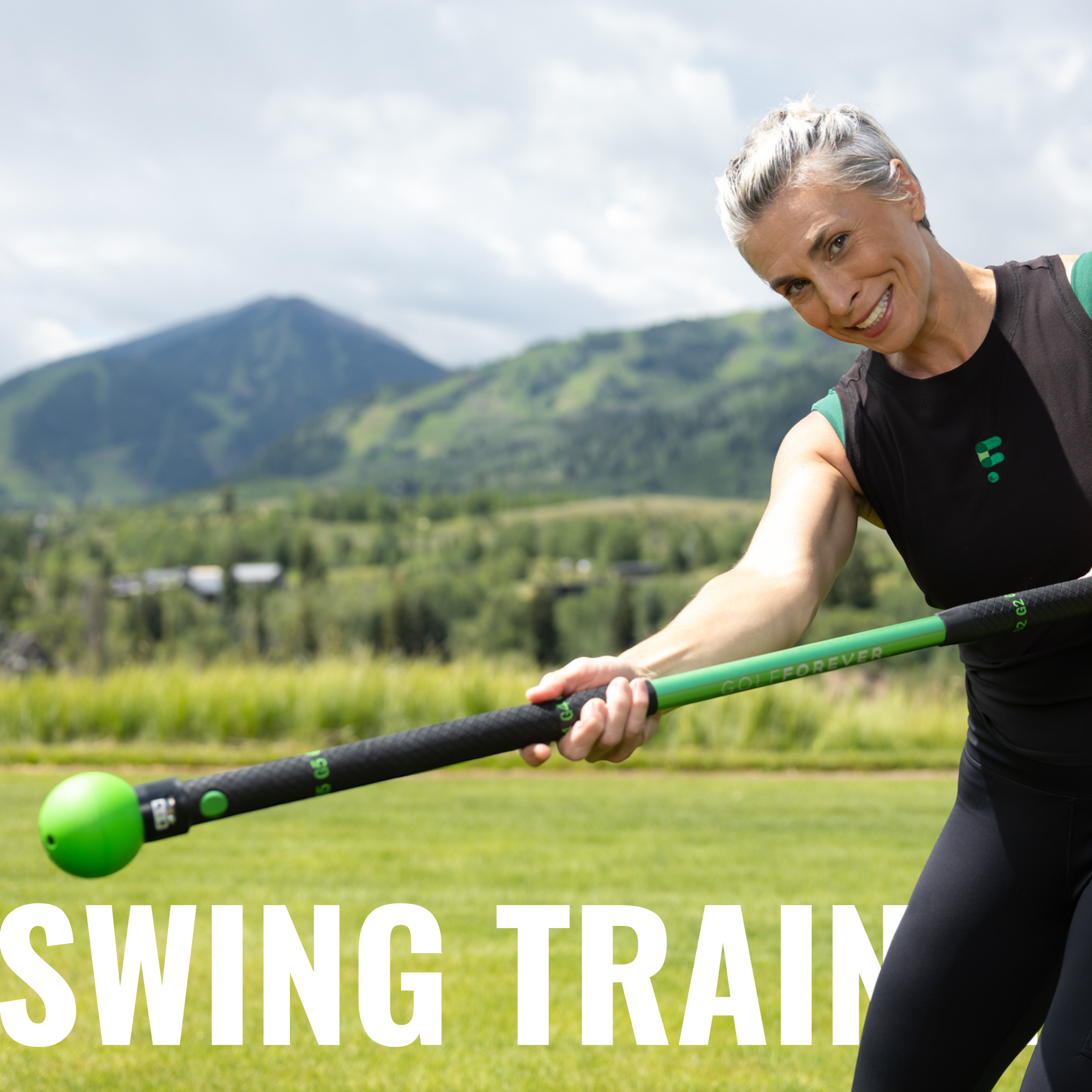 Person smiling and using a swing training tool outdoors with mountains in the background and text reading 'Swing Train.'