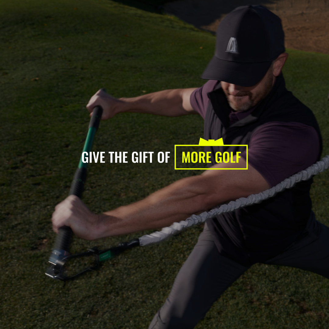Man swinging a golf training device on a green field, wearing a cap and athletic attire. Text overlay reads "Give the gift of more golf."