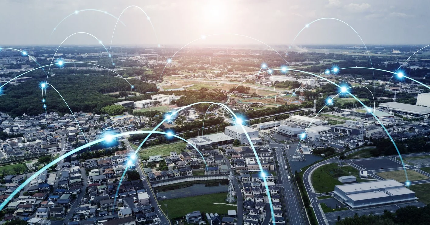 Aerial view of a city skyline with digital network connections overlaid, symbolizing connectivity and communication.
