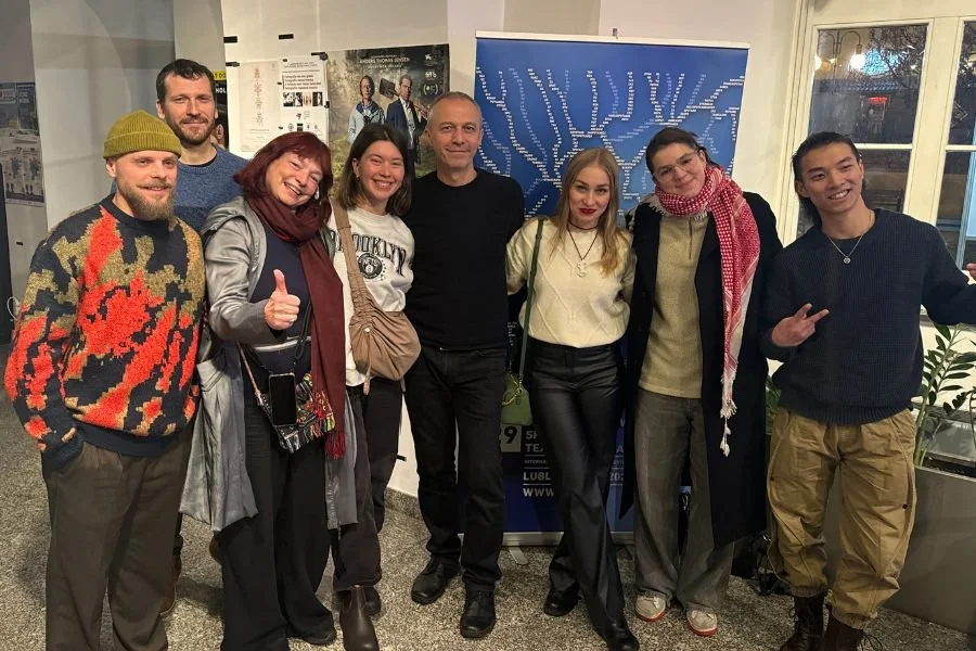 Group of artists pose in a theatre space