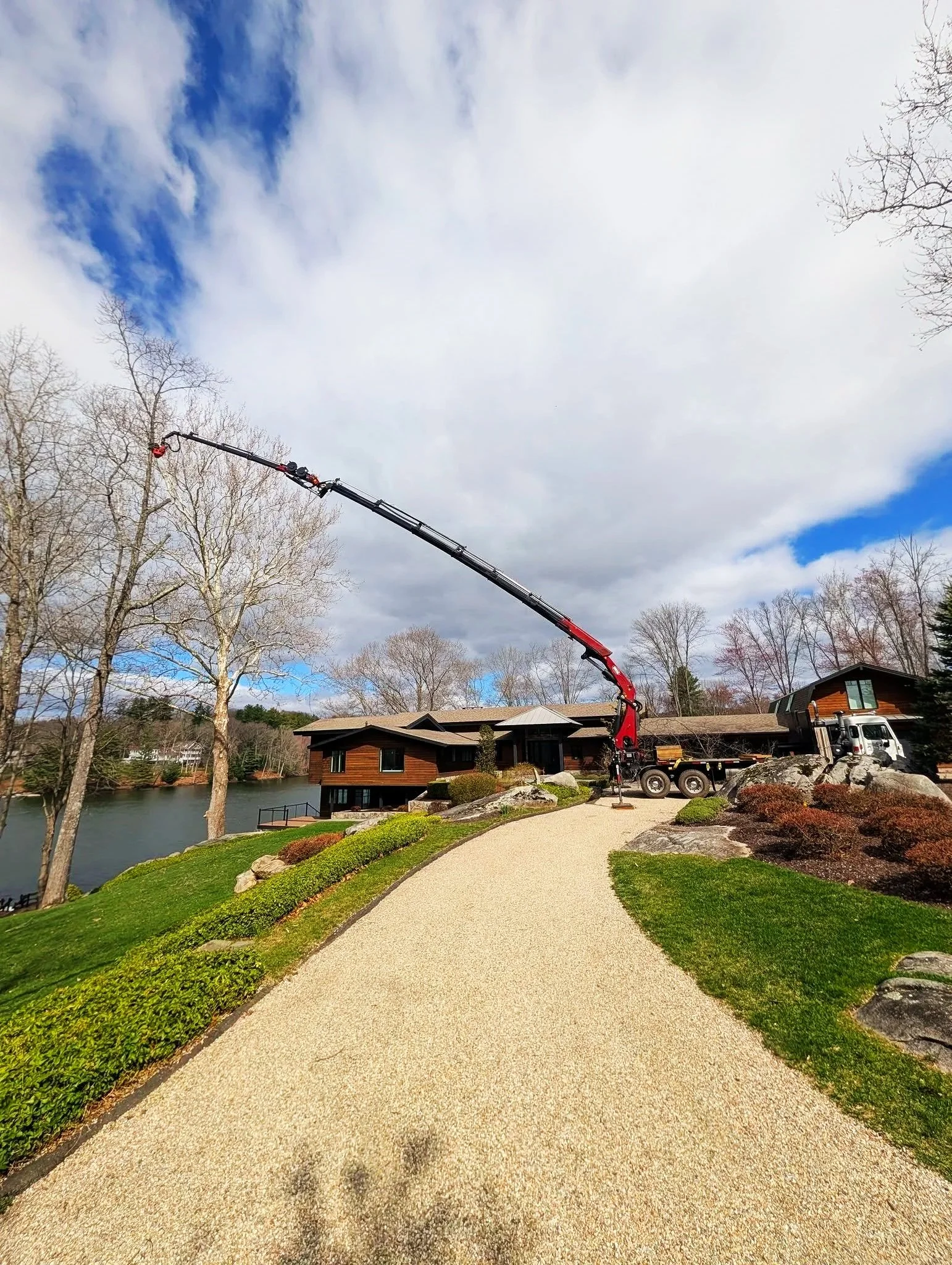 Red grapple saw crane at someone's house quickly removing a tree